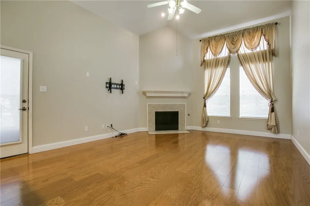 Unfurnished living room with a fireplace, a healthy amount of sunlight, and hardwood / wood-style floors