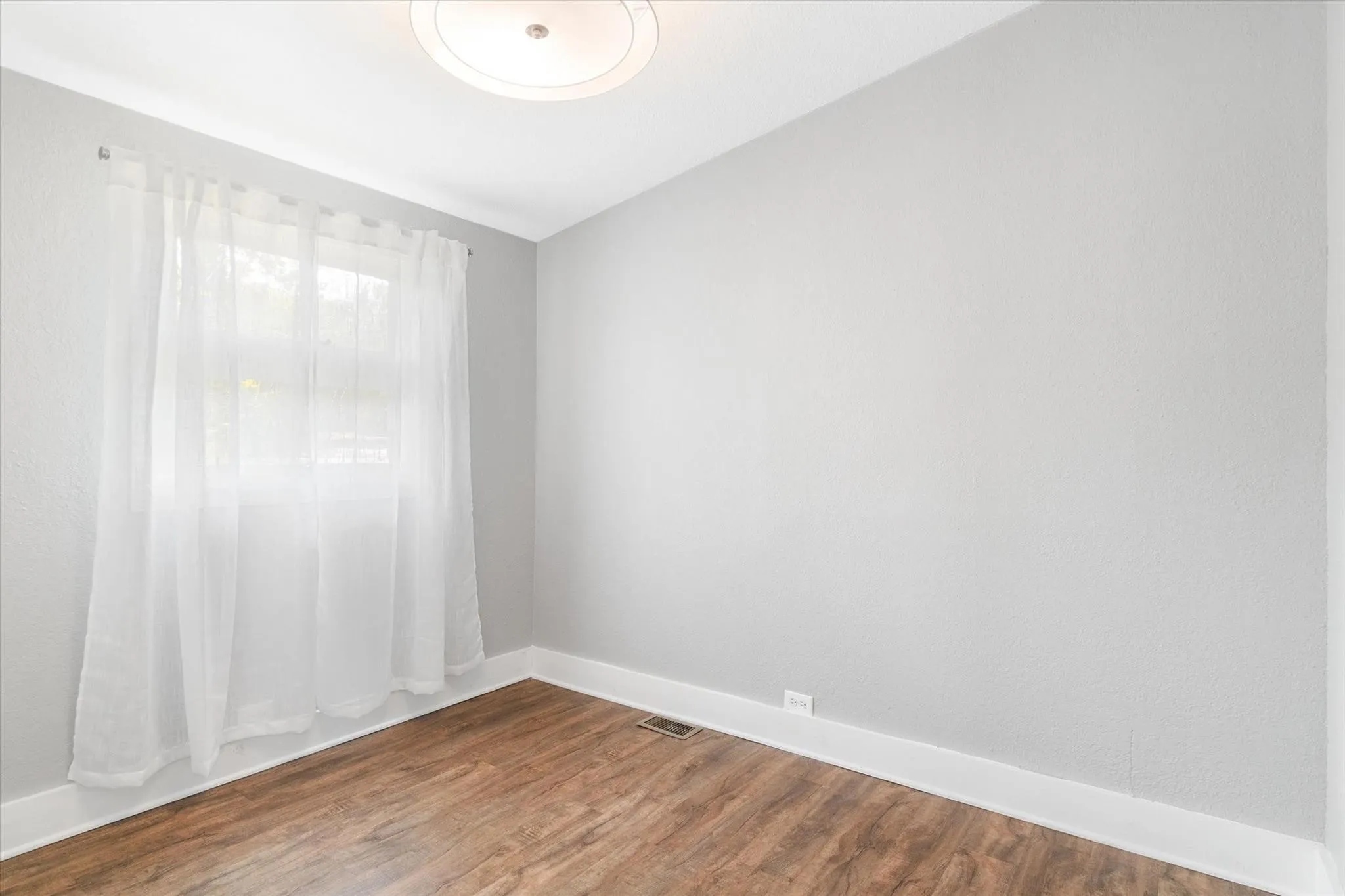 Recessed lighting, wood-finish flooring, and light-toned walls