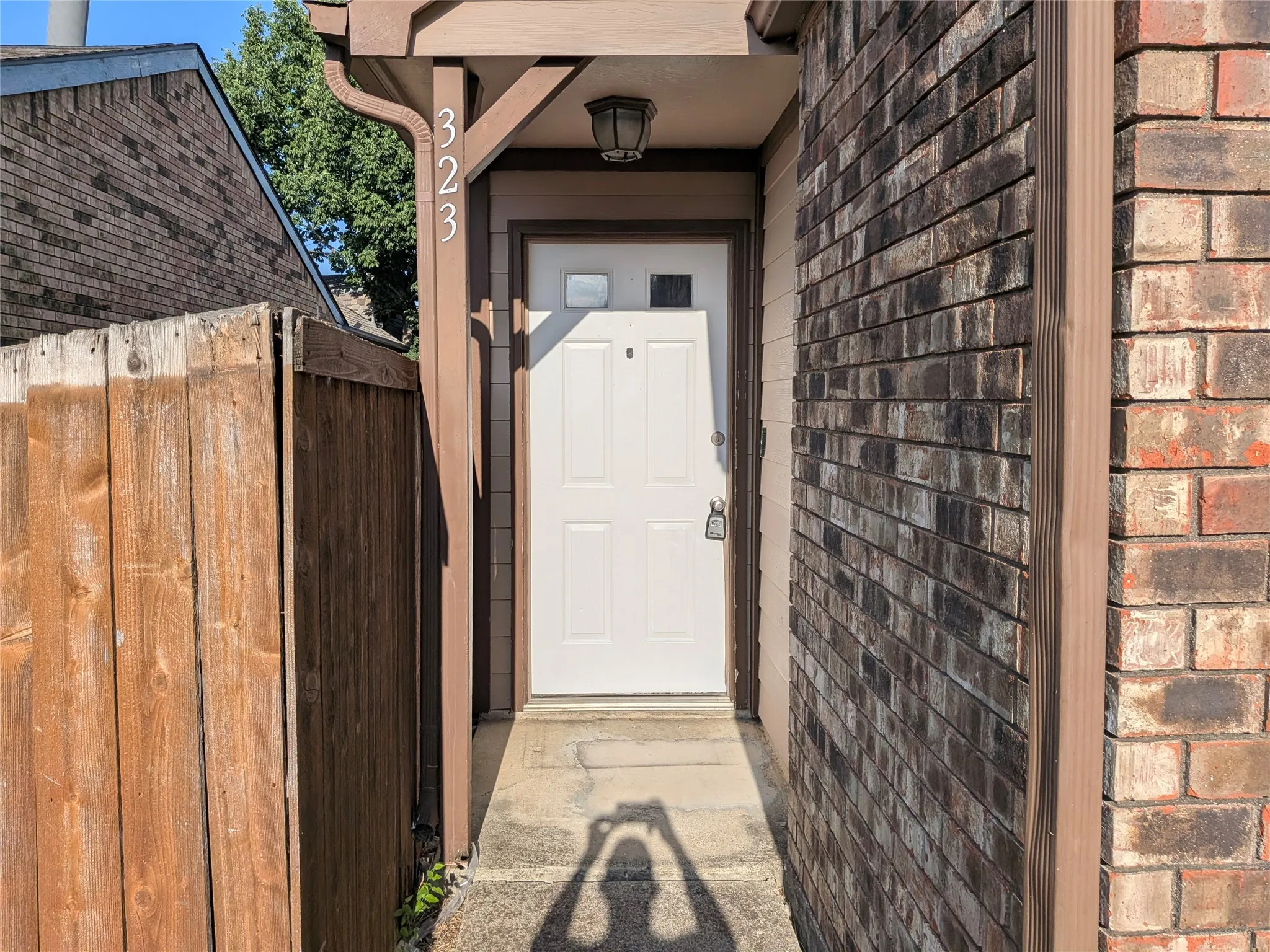 Entryway featuring a white door, overhead lighting fixture, and house numbering