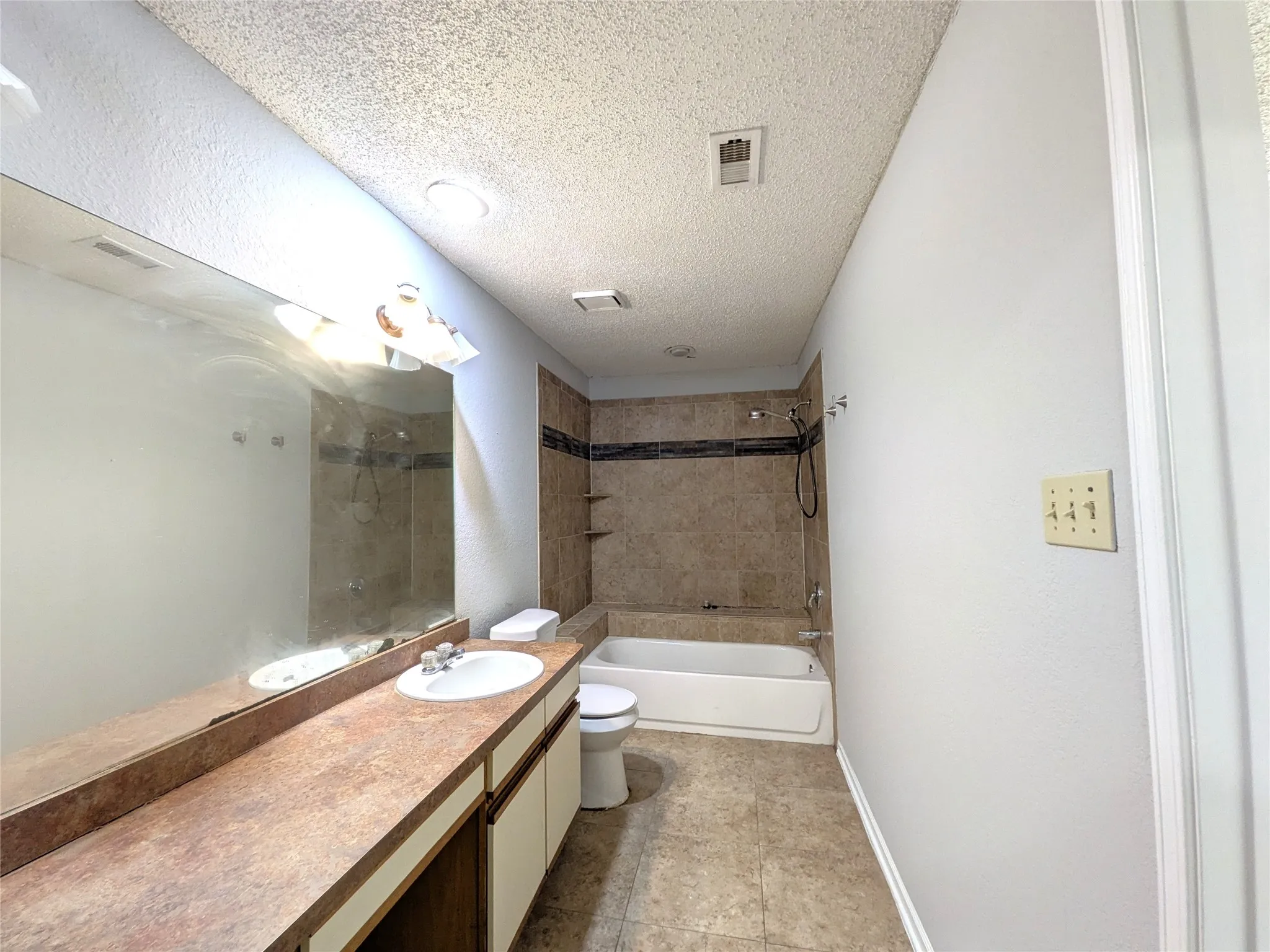 Integrated vanity with an undermount sink, a full-width mirror, and overhead lighting