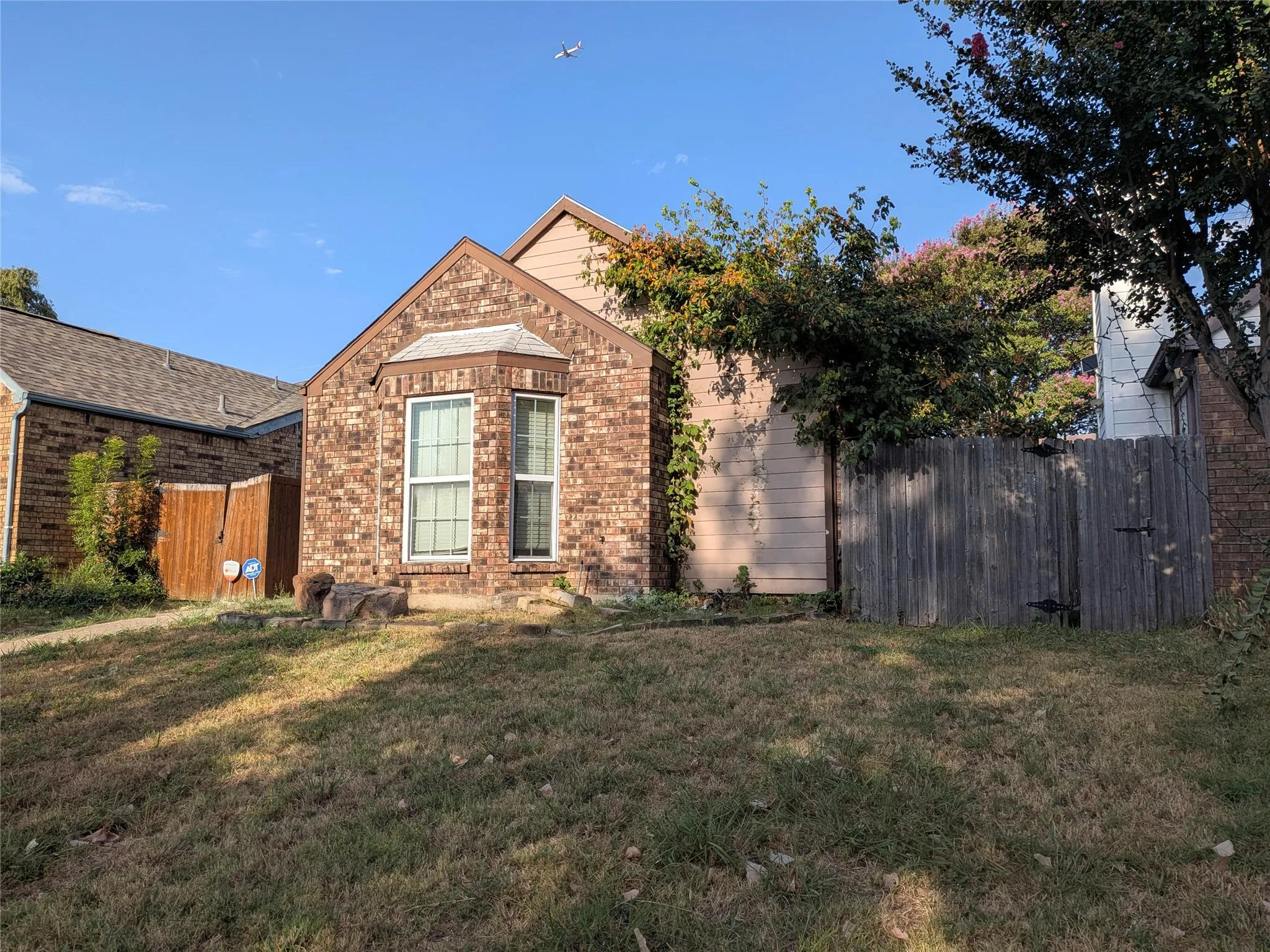 Brick exterior with a bay window and a sloped roofline