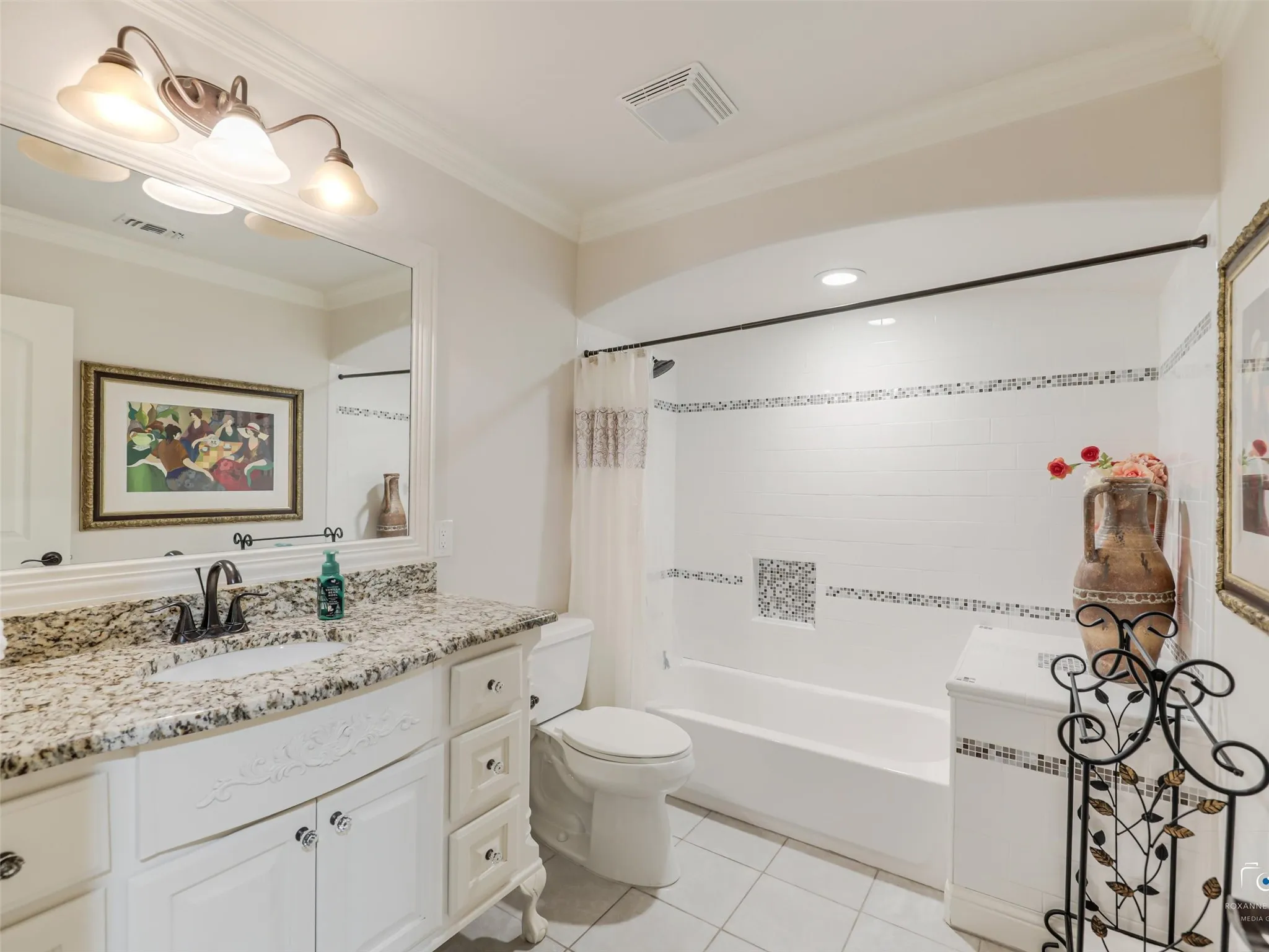 White vanity with stone countertop, undermount sink, and dark bronze faucet