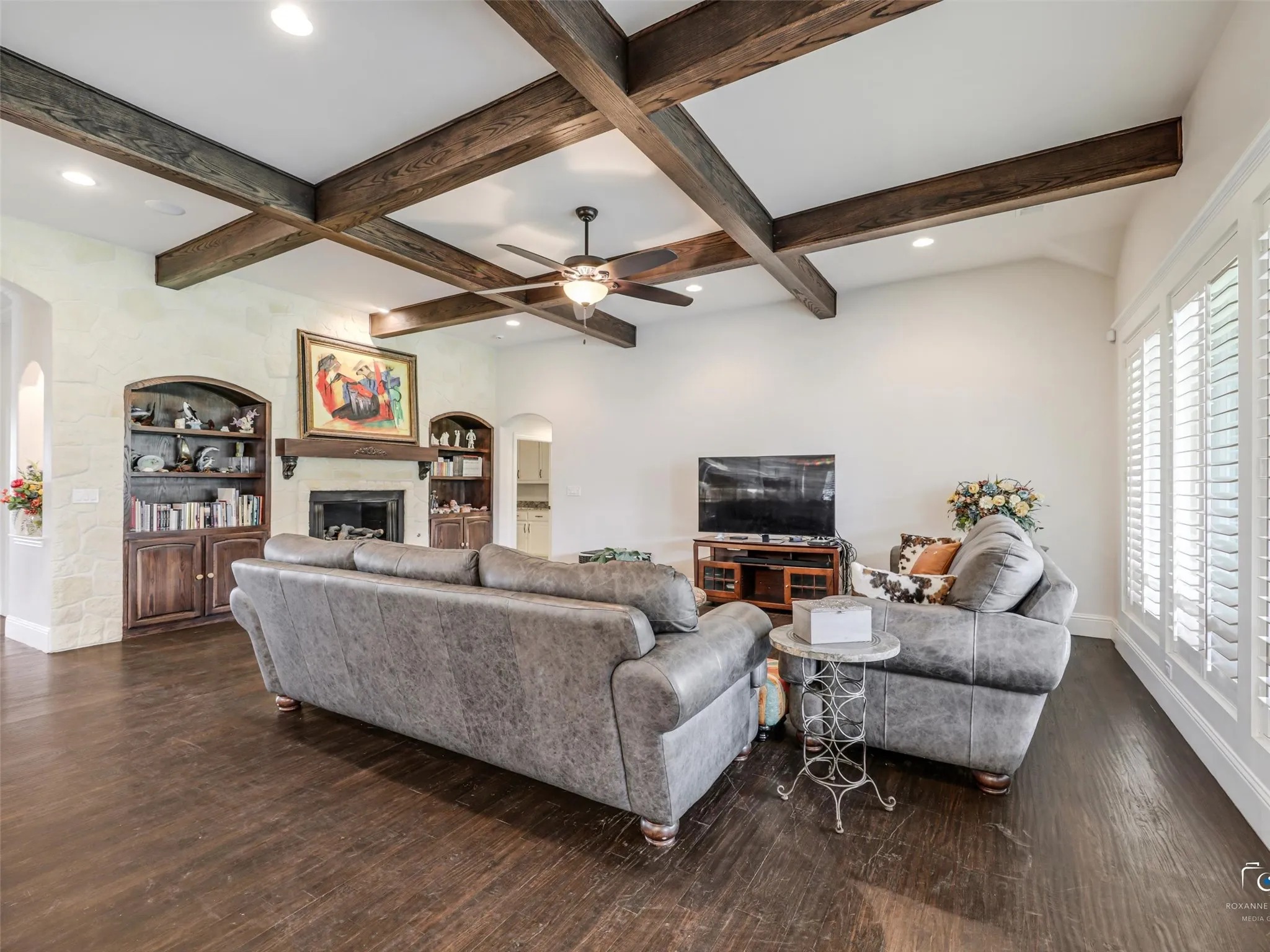 Living area featuring dark wood-finish flooring, exposed ceiling beams, a ceiling fan, recessed lighting, and white plantation shutters