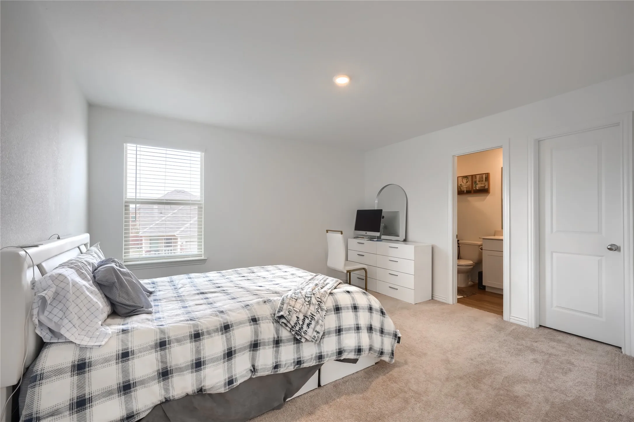 Neutral wall color, recessed lighting, window with blinds, carpeted flooring, and a solid interior door