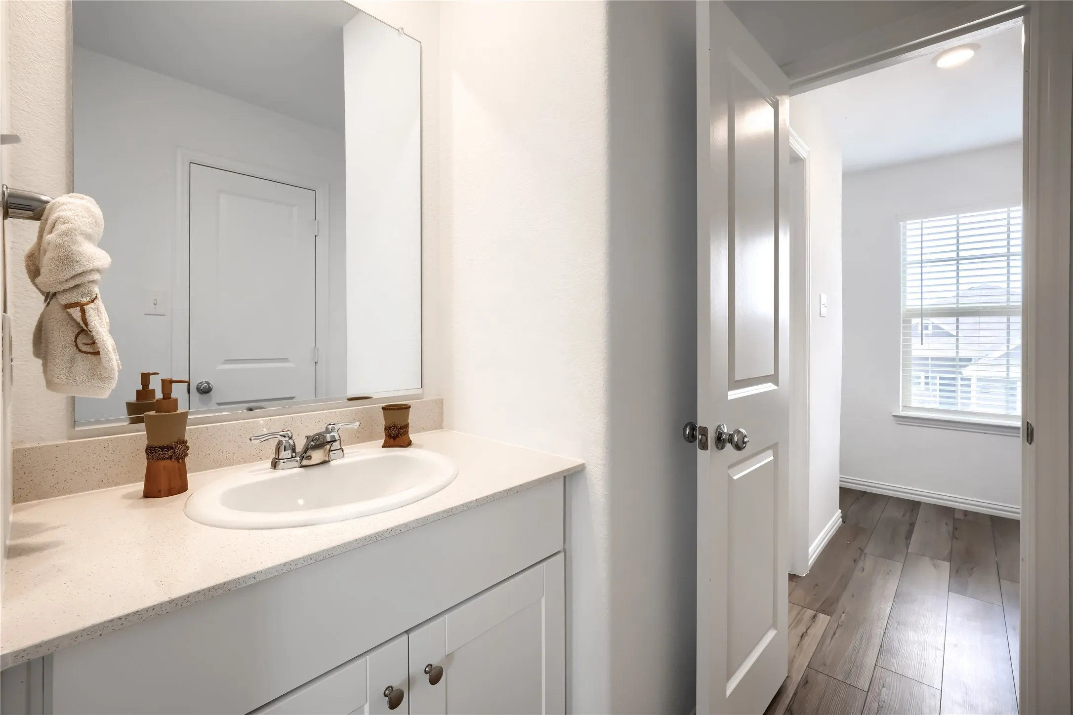 Spa-inspired primary bathroom featuring a floating vanity with ample storage, quartz countertop, and polished chrome fixtures