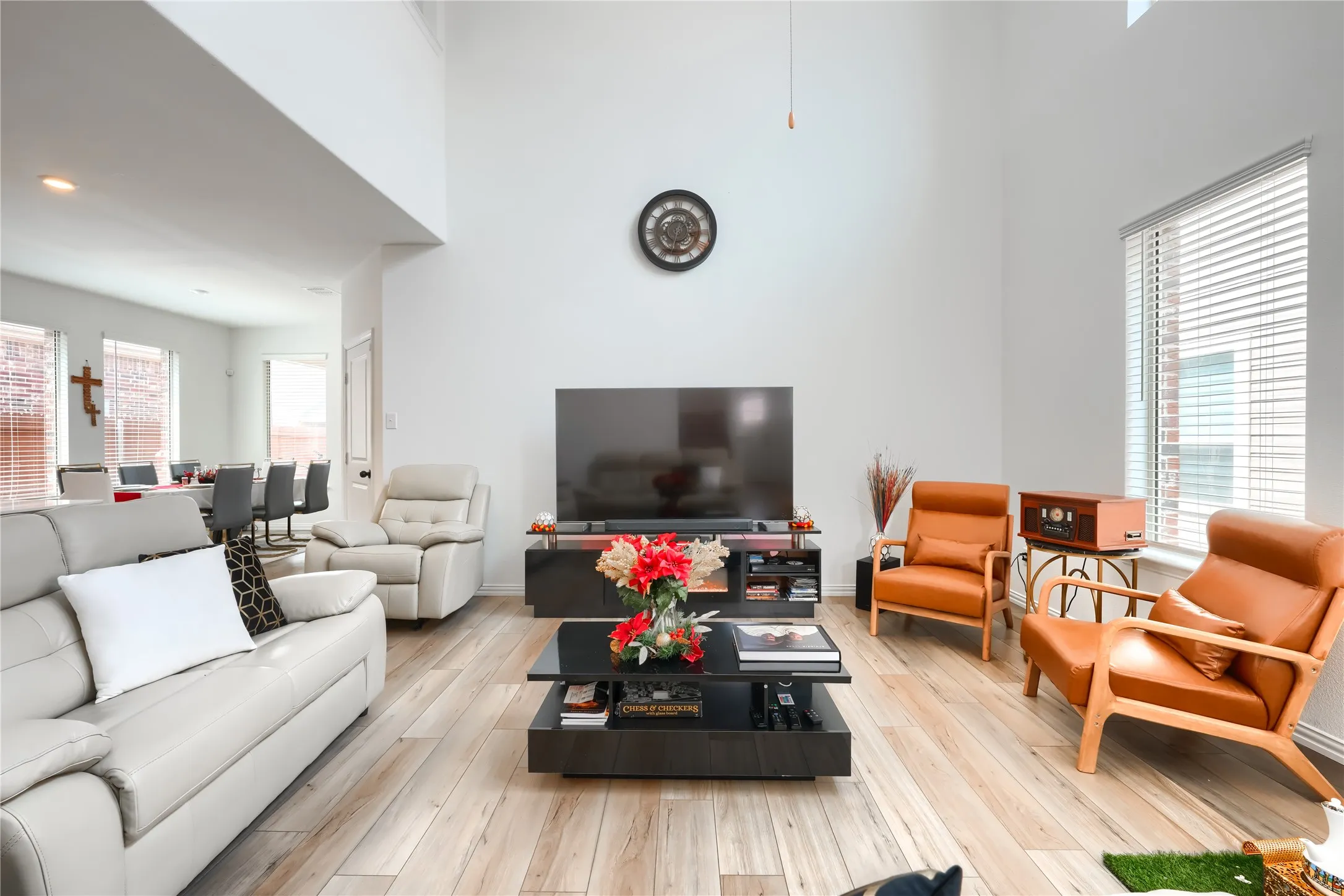 High ceilings with recessed lighting, wood-finish flooring, large window with blinds, and an open concept layout