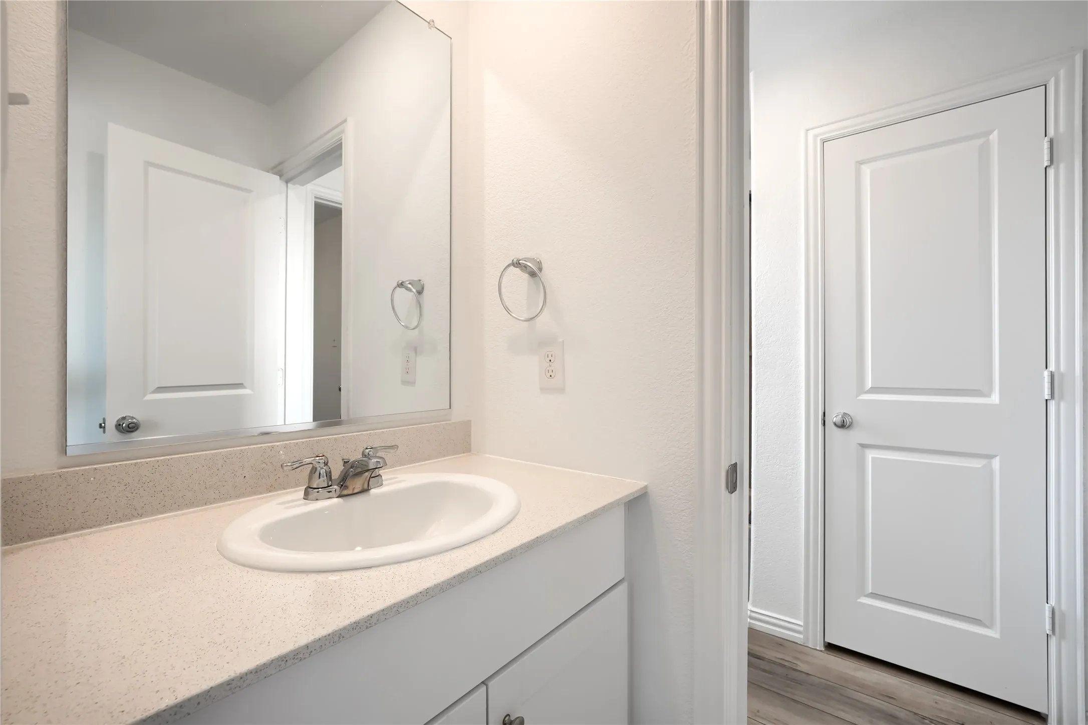 Built-in vanity with an undermount sink, chrome faucet, and integrated backsplash