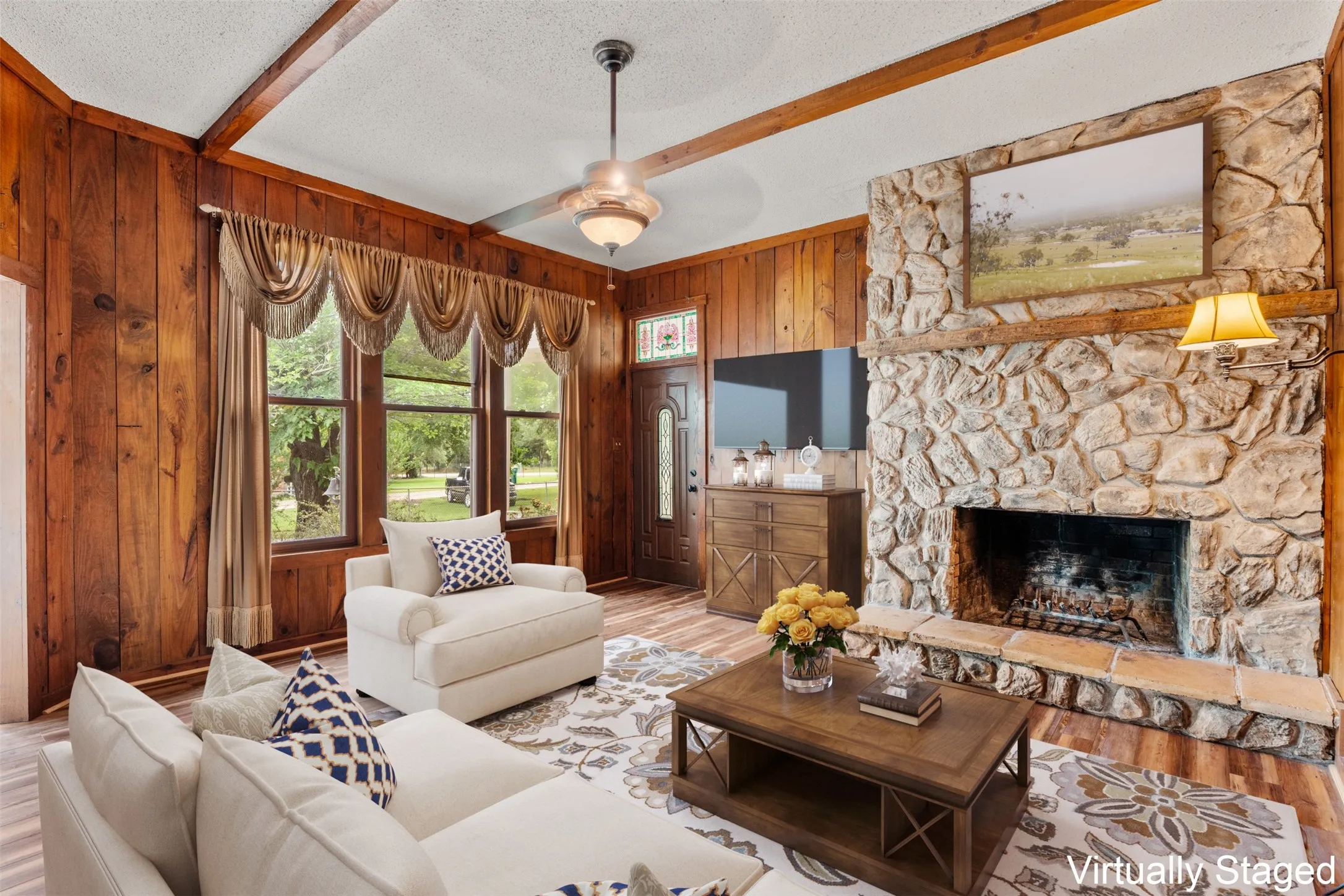 Cozy family/den area with large windows and floor-to-ceiling stone woodburning fireplace (Virtually Staged)