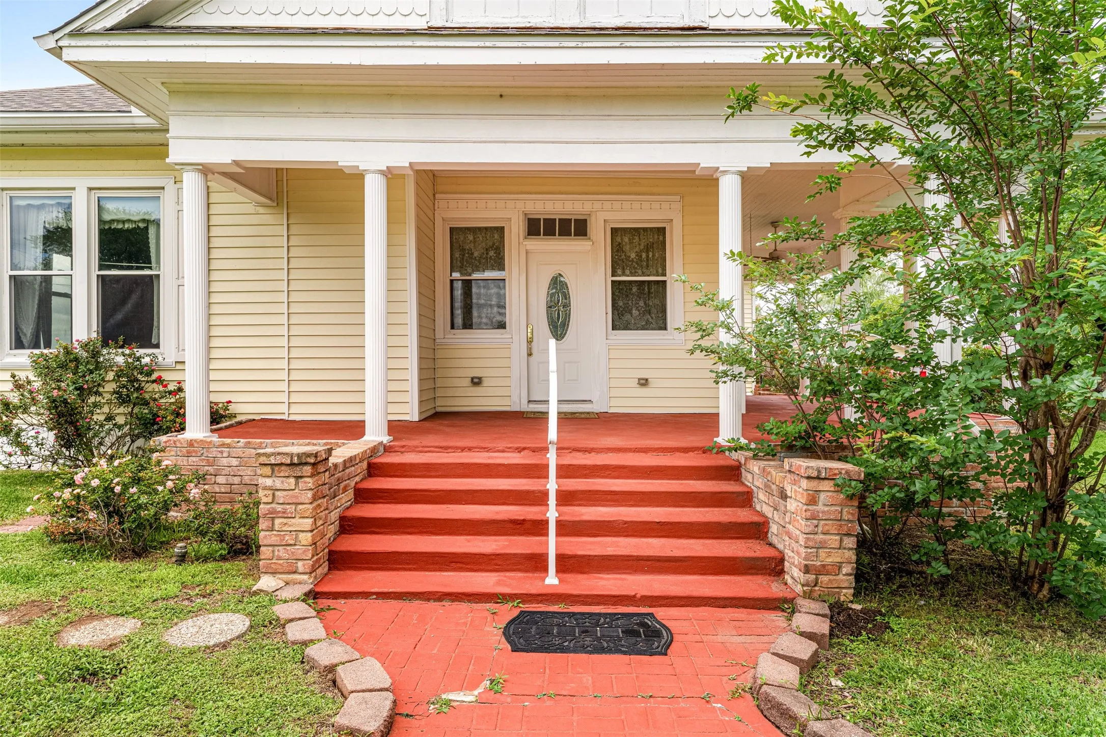 Front View entrance of the home with grand steps/rails onto the wraparound porch