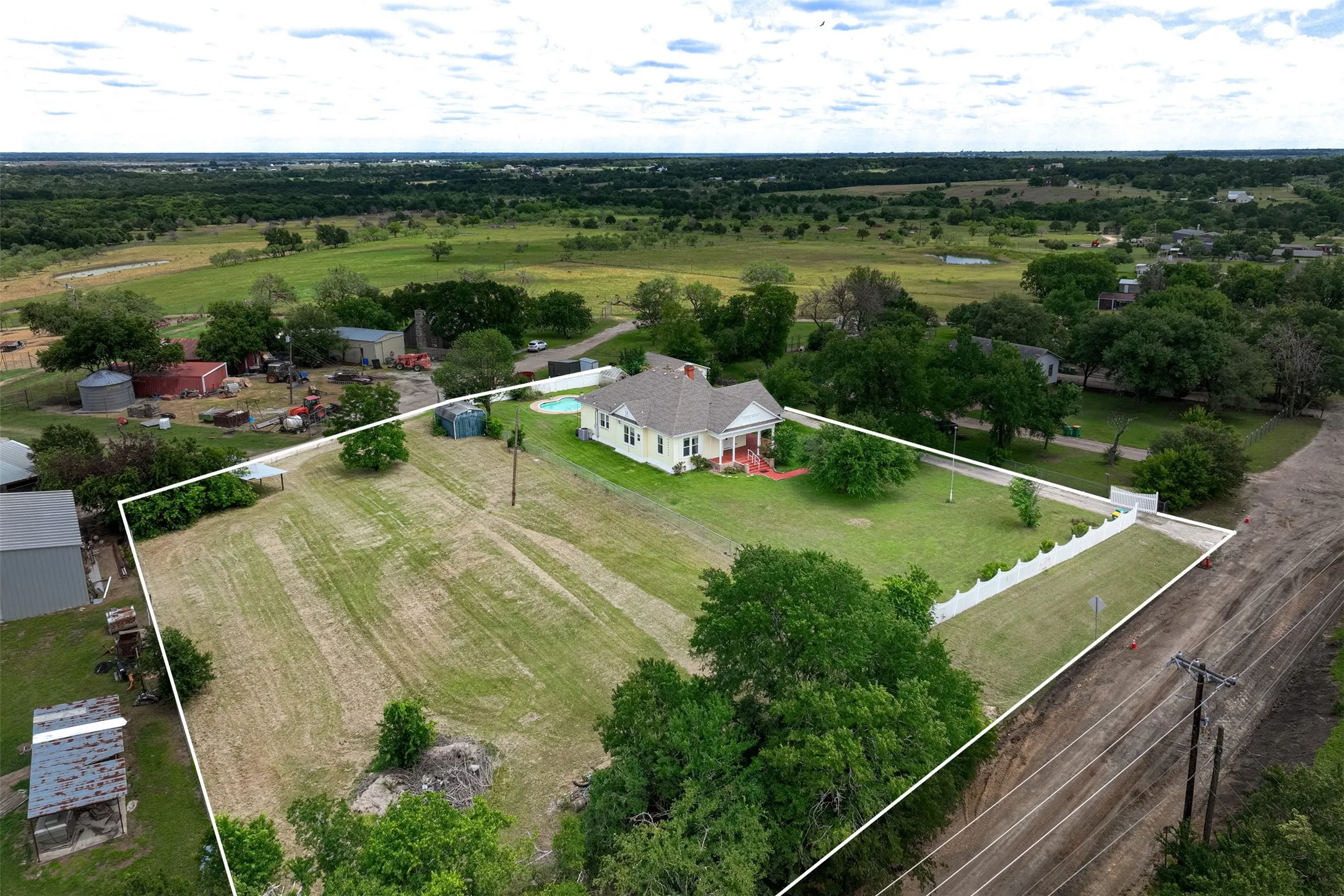 Aerial View of the home, reflecting the home, pool, storage barn building, greenhouse and acreage