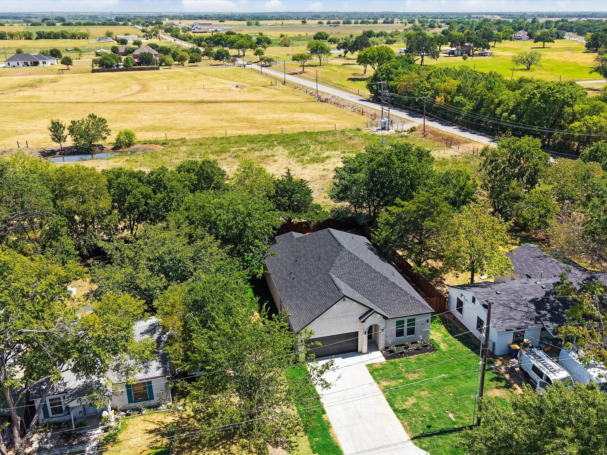 Single-story residence featuring a dark shingle roof and a light-colored exterior