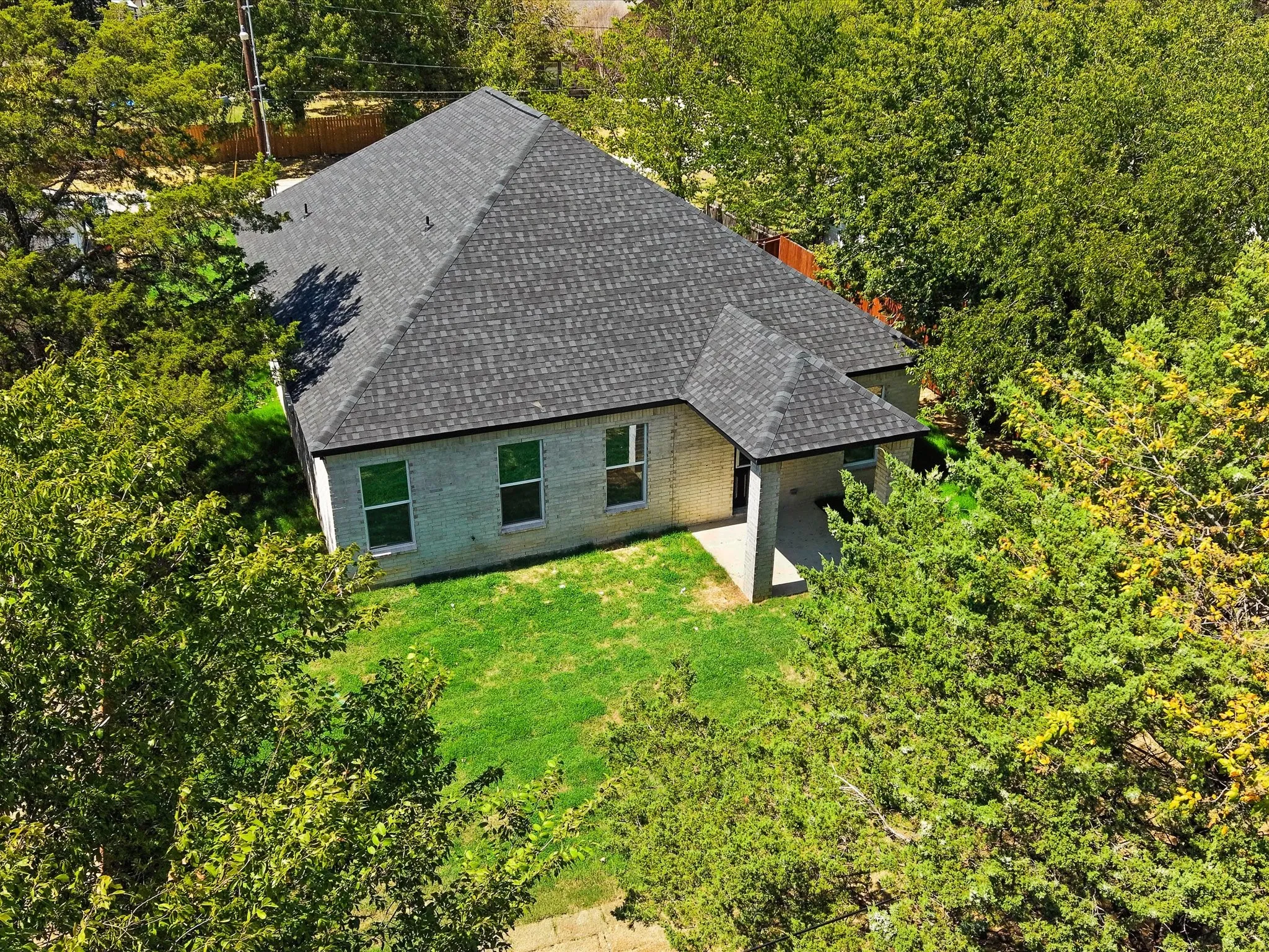 Light-colored brick exterior with a dark shingle roof