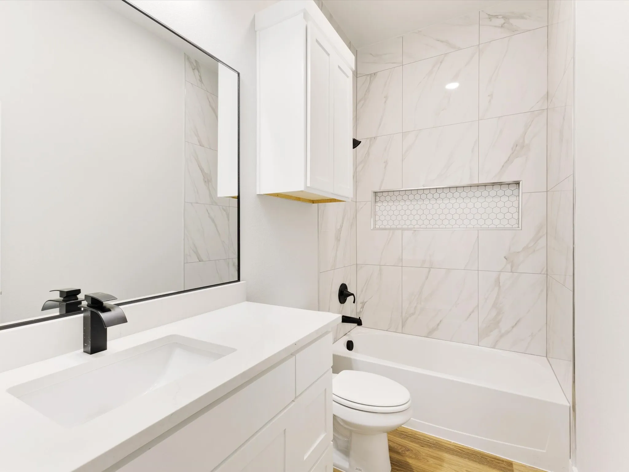 White vanity with an integrated rectangular sink and matte black faucet
