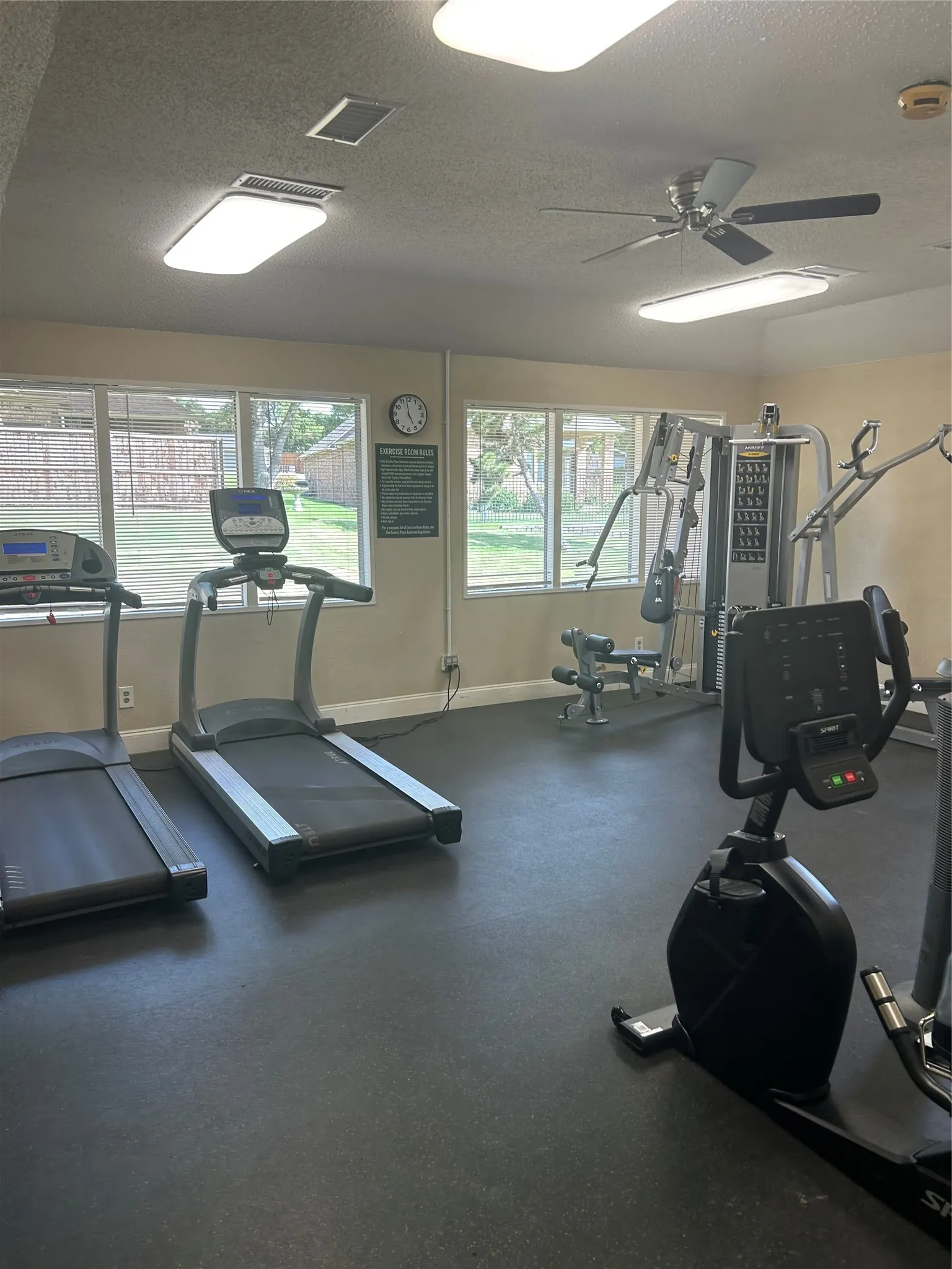 Dedicated community fitness room featuring multiple treadmills, stationary bike, and strength training equipment