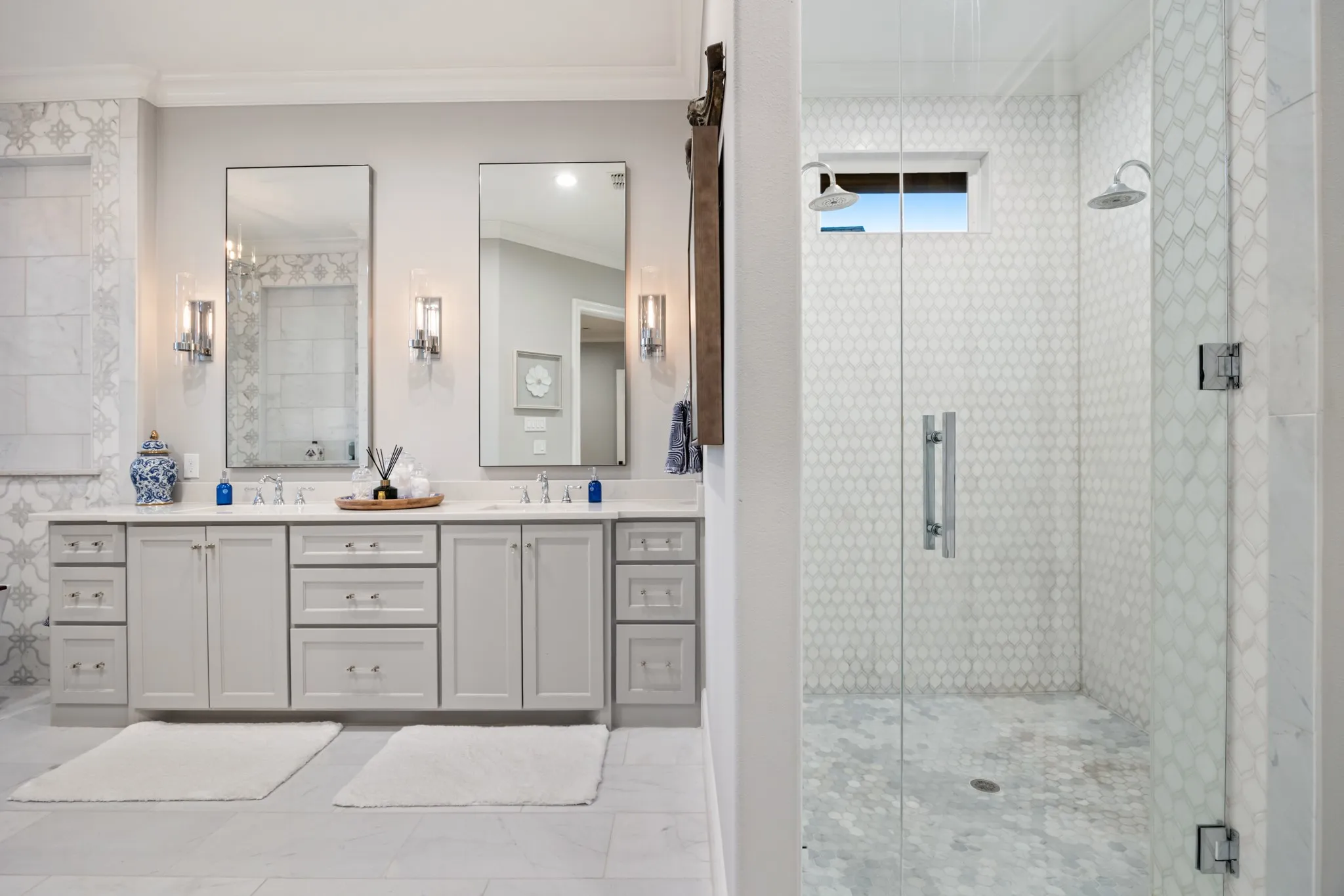 Primary bath features a walk-in shower with dual shower heads, spa-like vanity.