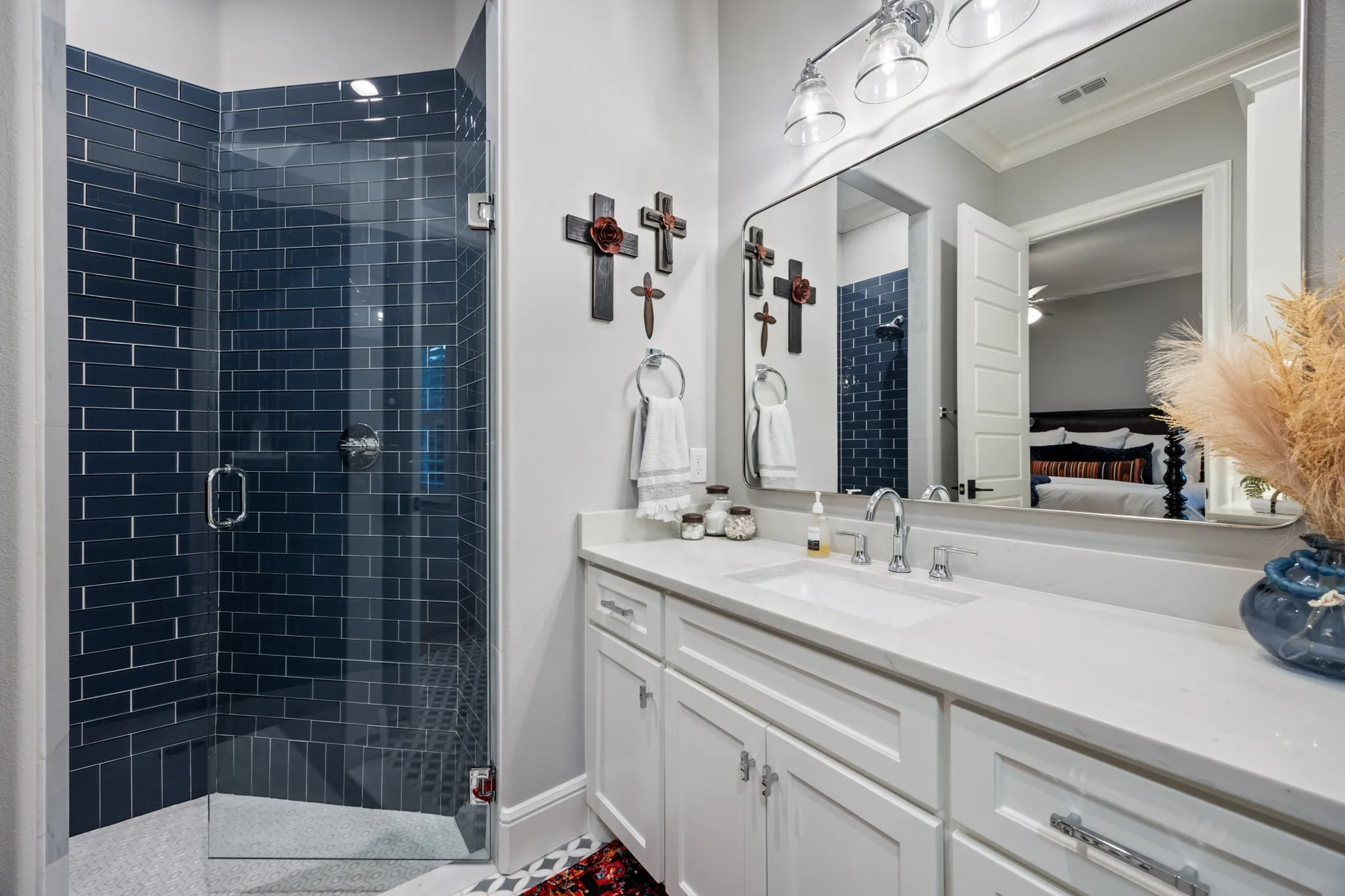 En-suite bath detailed with a dark tile shower surround and a single vanity.