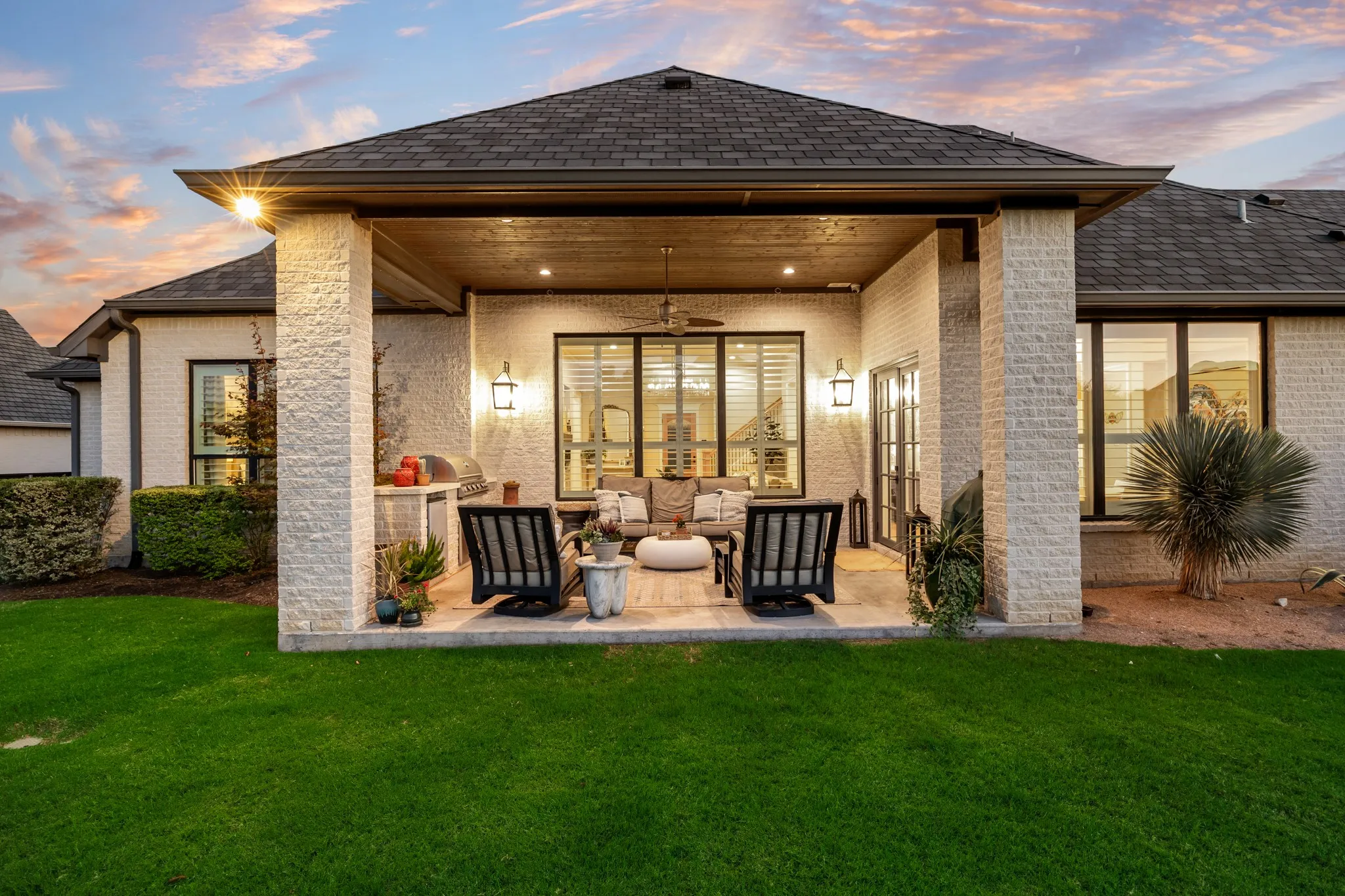 Outdoor kitchen made for long evenings, framed by a covered patio and warm lighting.
