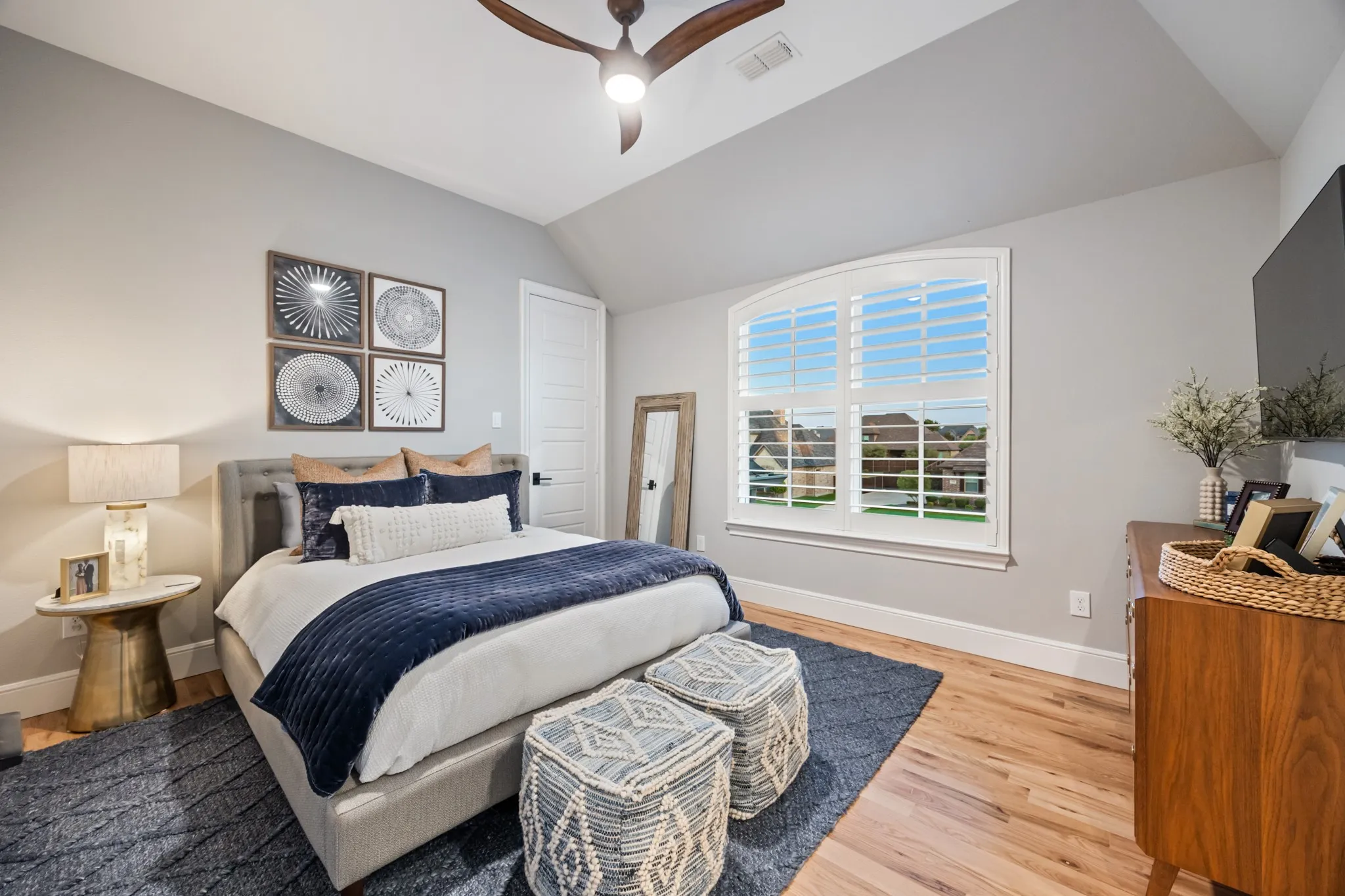 Bright upstairs bedroom with oak hardwood floors and picture-window views.