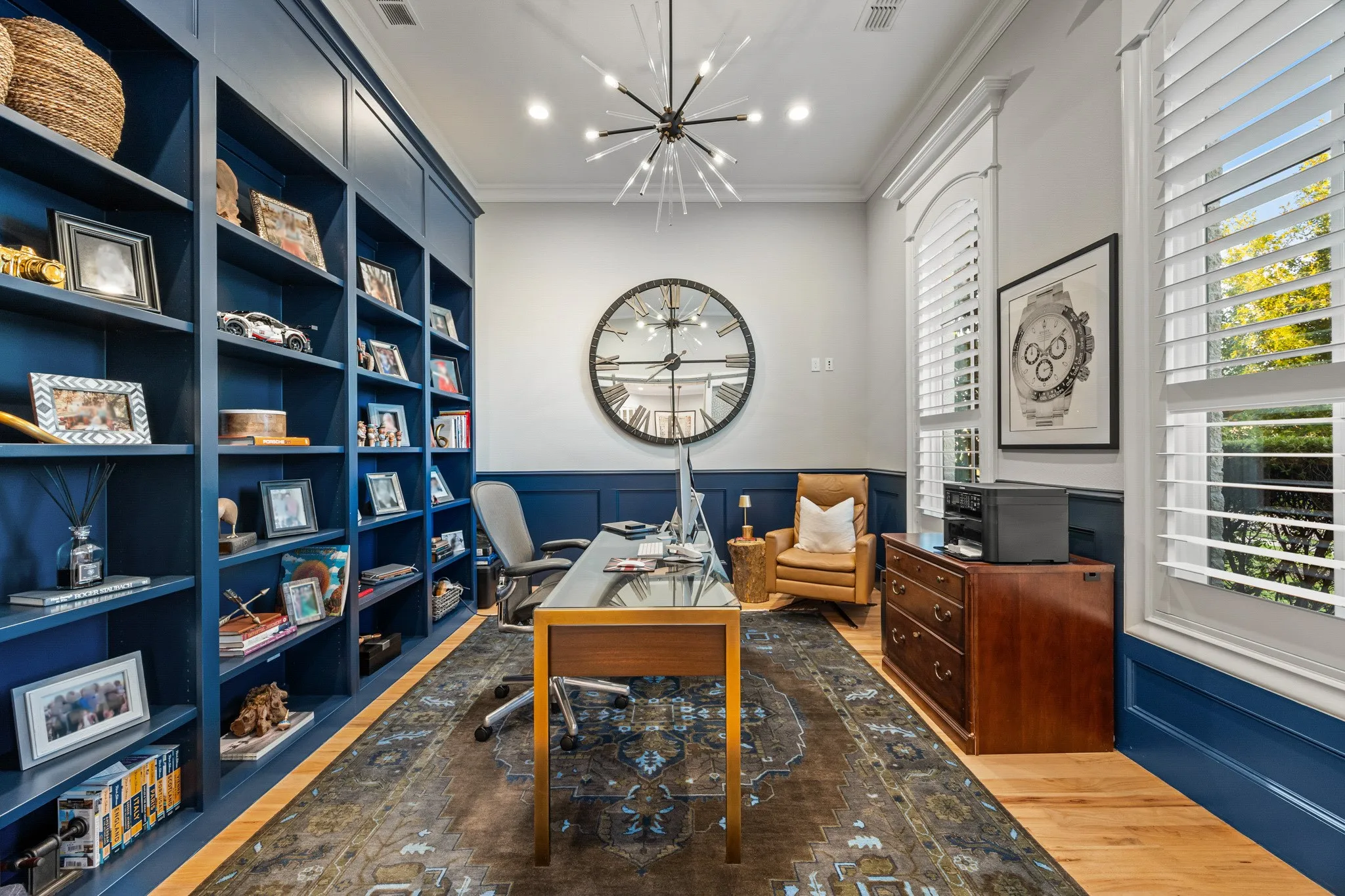 Private office wrapped in navy built-in shelving, a quiet spot for working from home.