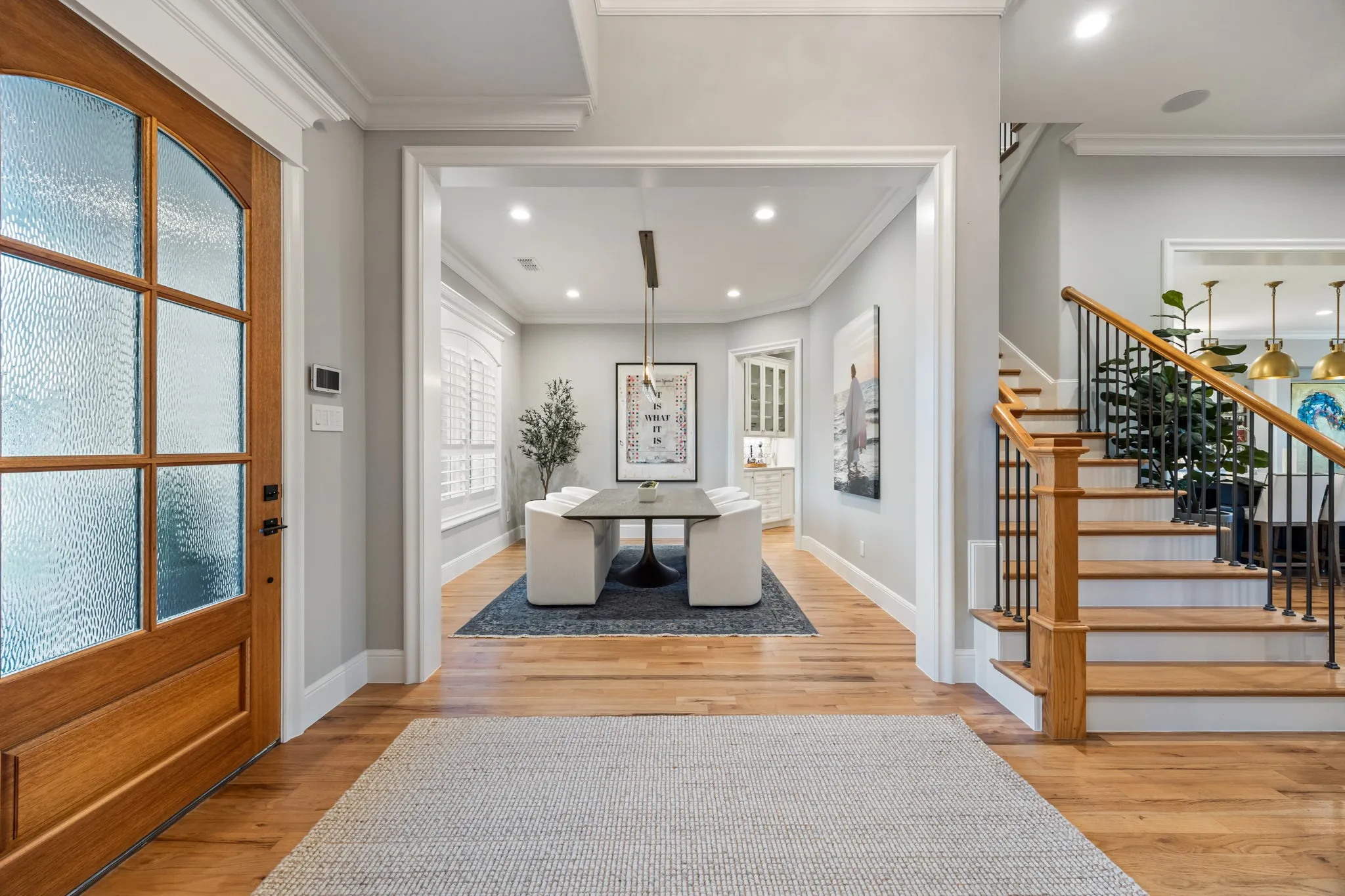 Formal dining room opens off the foyer, framed by an oak staircase and warmed by natural light.