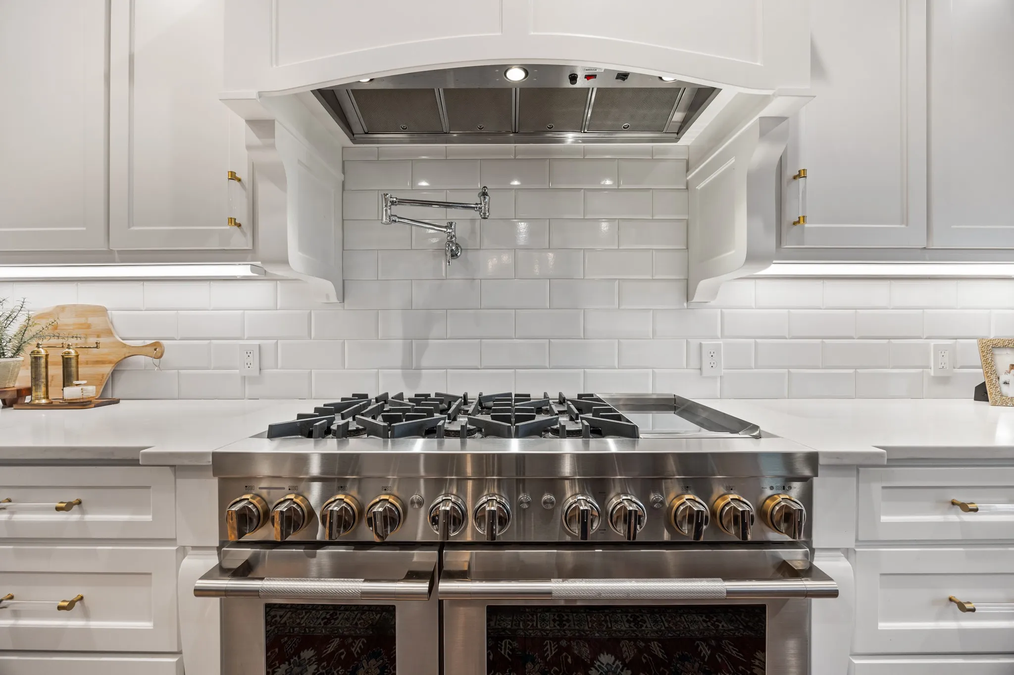 JennAir range and hood take center stage against a striking marble backsplash.