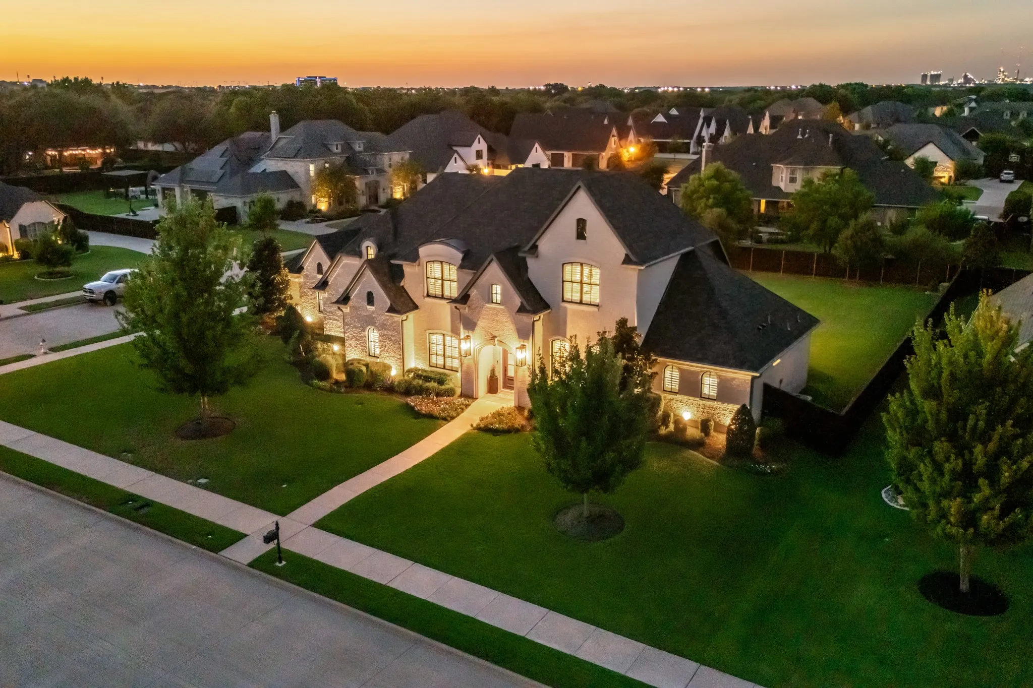 Twilight aerial view captures the custom stone-and-brick facade on nearly half an acre in gated Somercrest Estates.