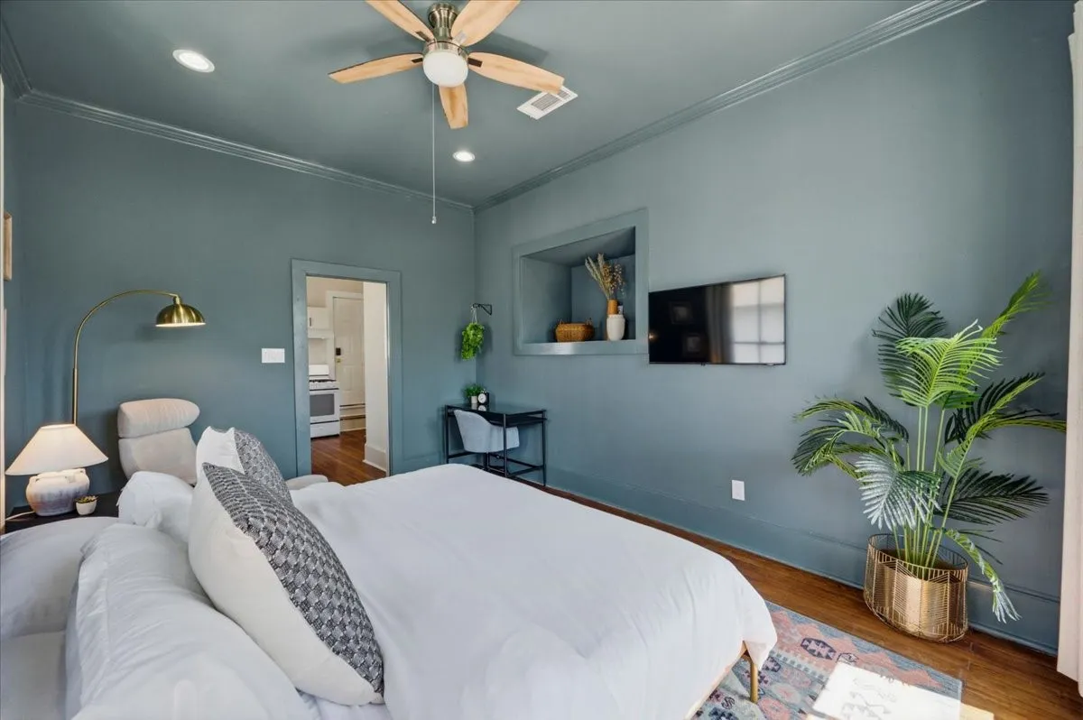 Hardwood flooring, recessed lighting, ceiling fan with light, built-in wall niche, and crown molding
