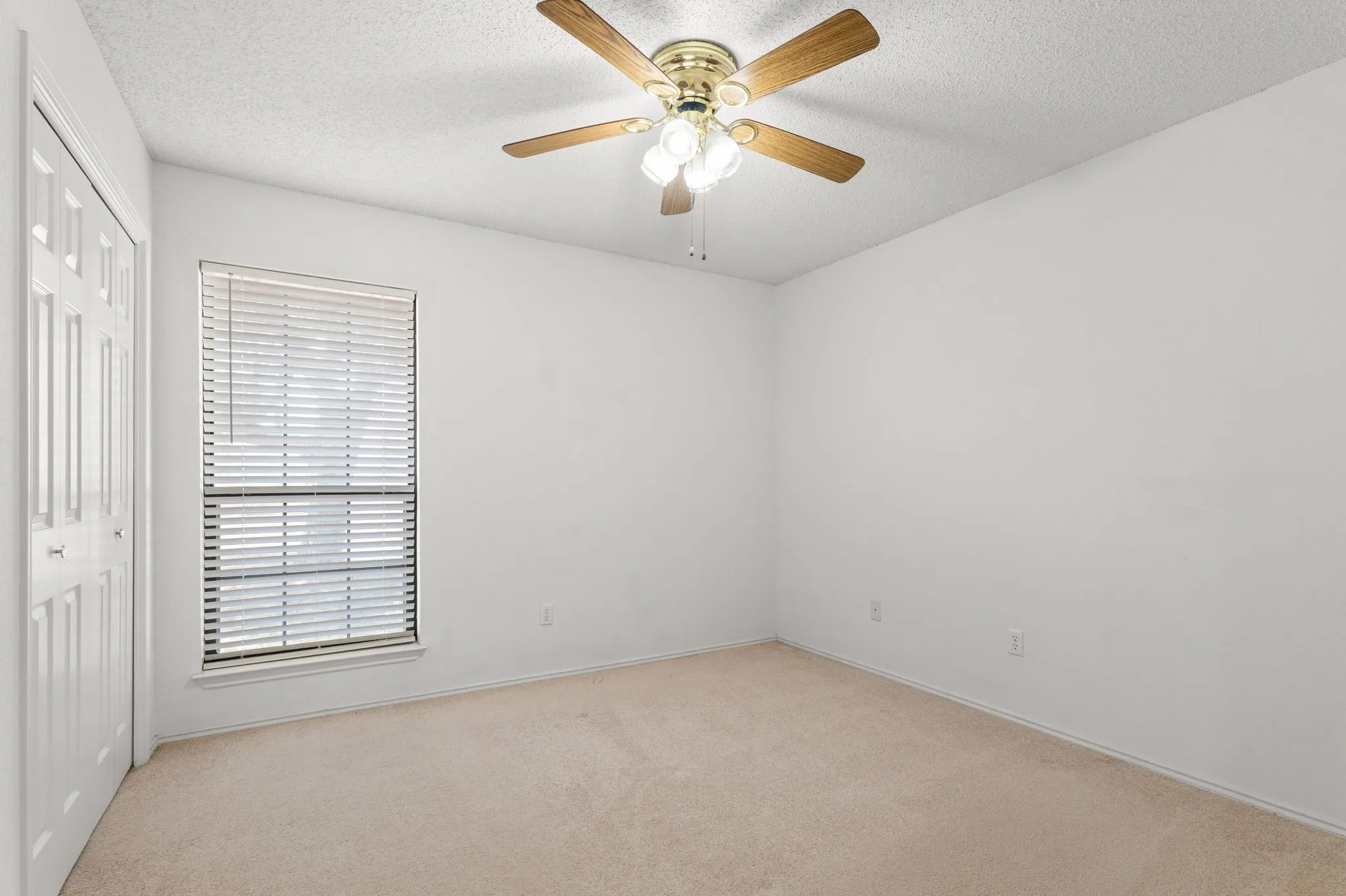 Neutral wall finishes, carpeted flooring, window with blinds, and ceiling fan with integrated lighting