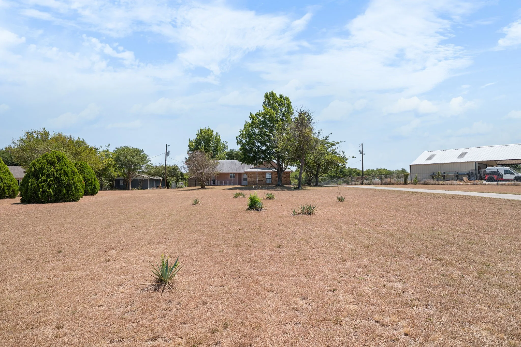 Expansive lot featuring a single-story residence and a large metal outbuilding