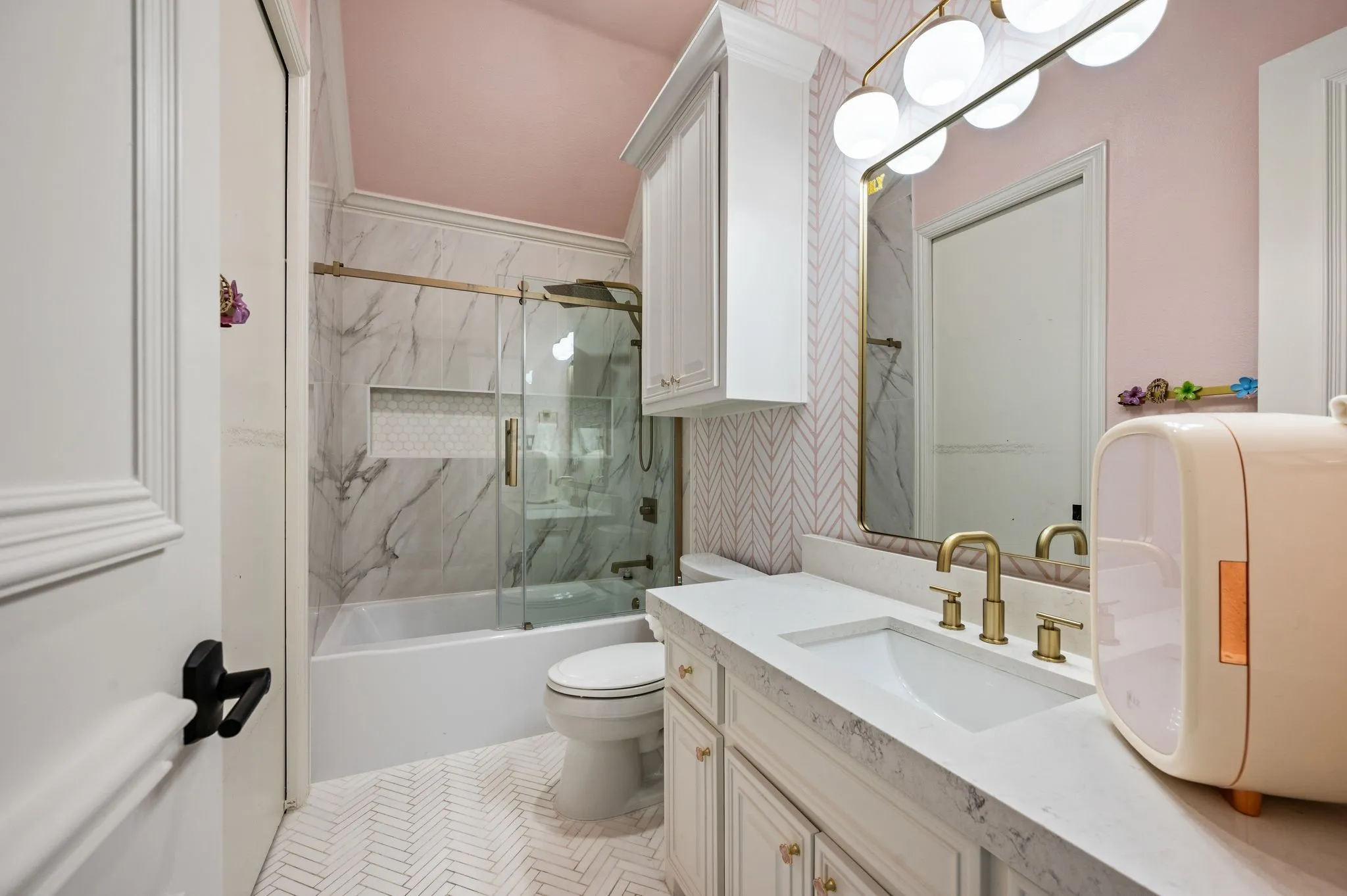 Bathroom featuring a vanity with an integrated sink and gold-finish hardware