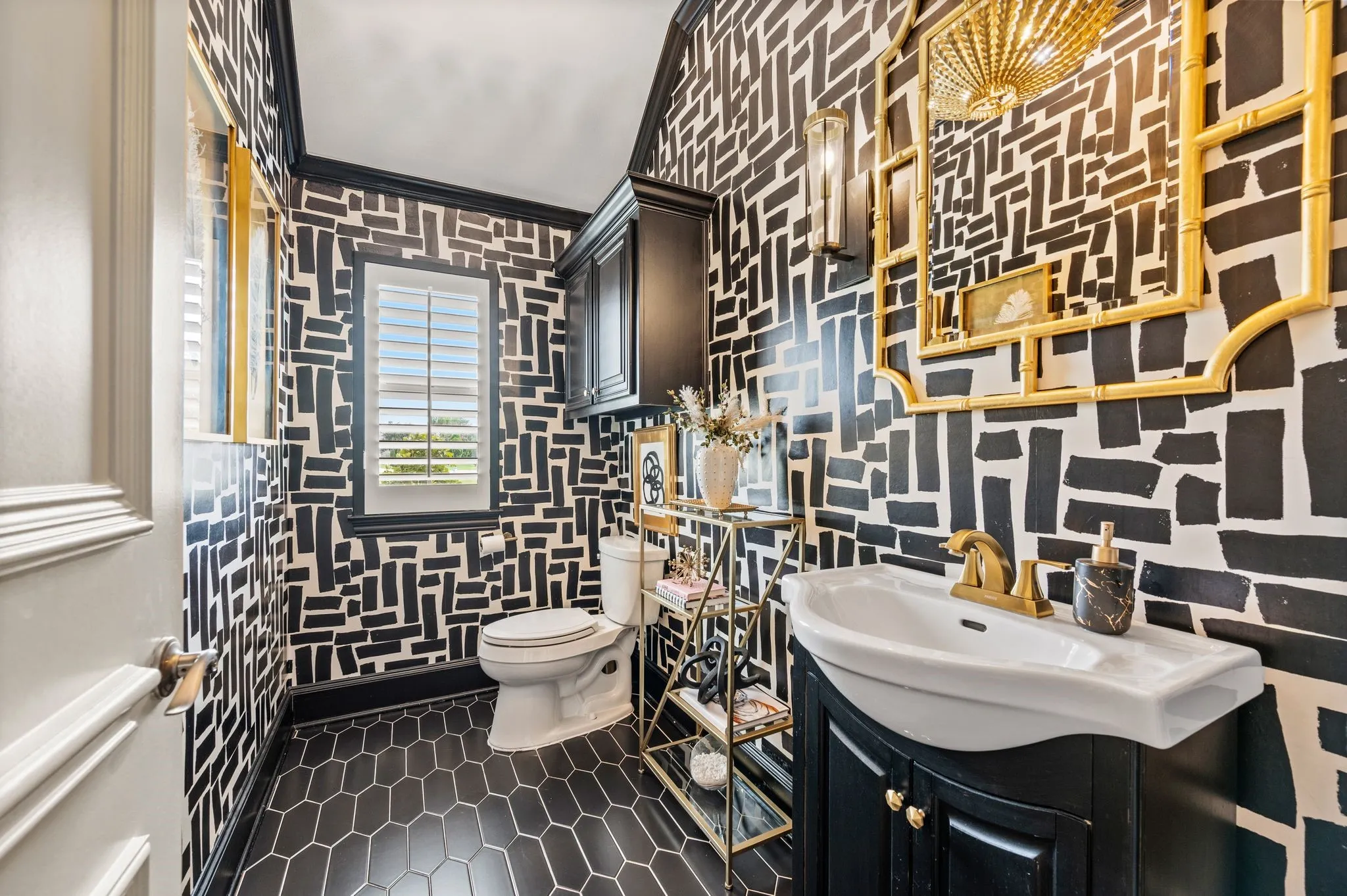 Powder room featuring bold patterned wallpaper and dark hexagonal floor tiles