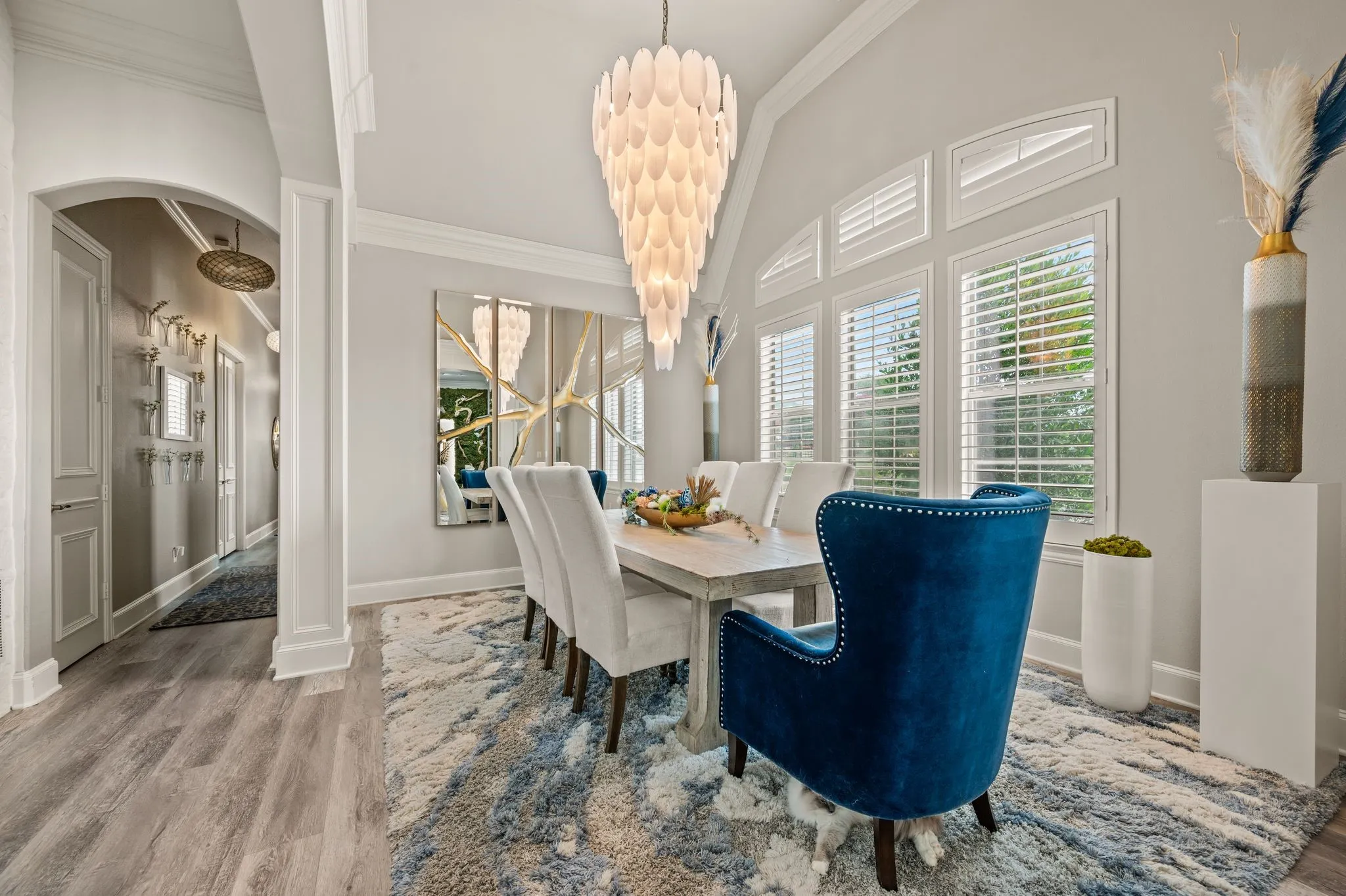 Dining space featuring wood-finish flooring, an arched entryway, and crown molding