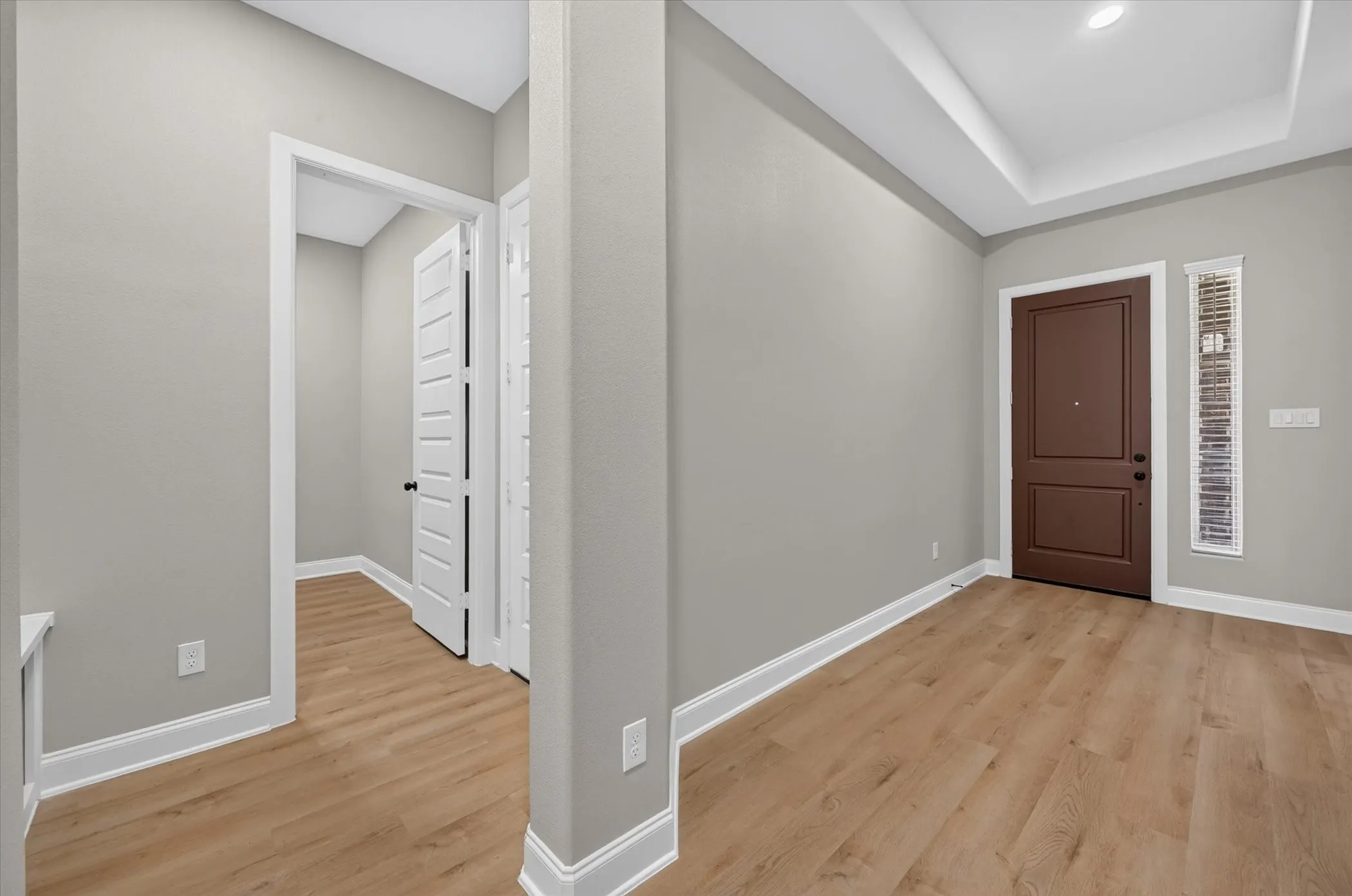 Warm wood-finish flooring complements the neutral wall tones