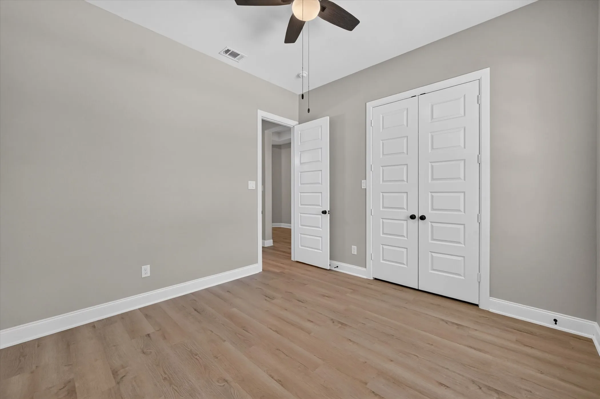 Neutral wall finishes, wood-finish flooring, and white trim