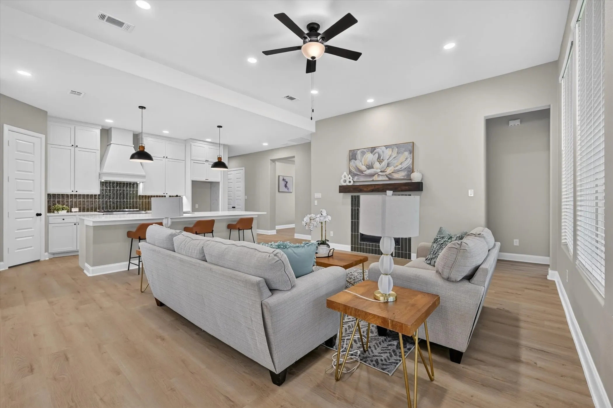 Light wood-finish flooring throughout, recessed lighting, and a ceiling fan