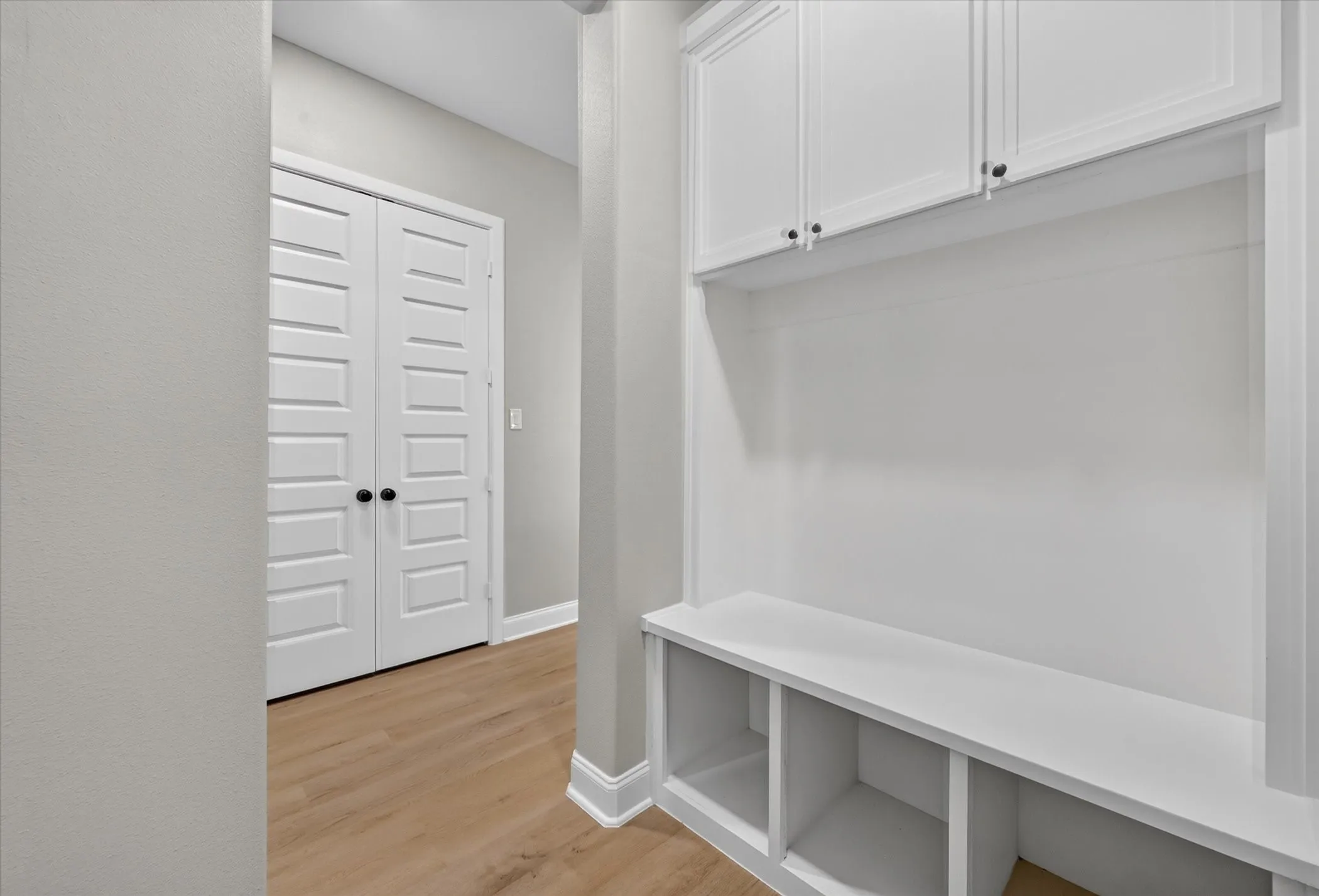 Built-in white cabinetry and bench seating with open storage