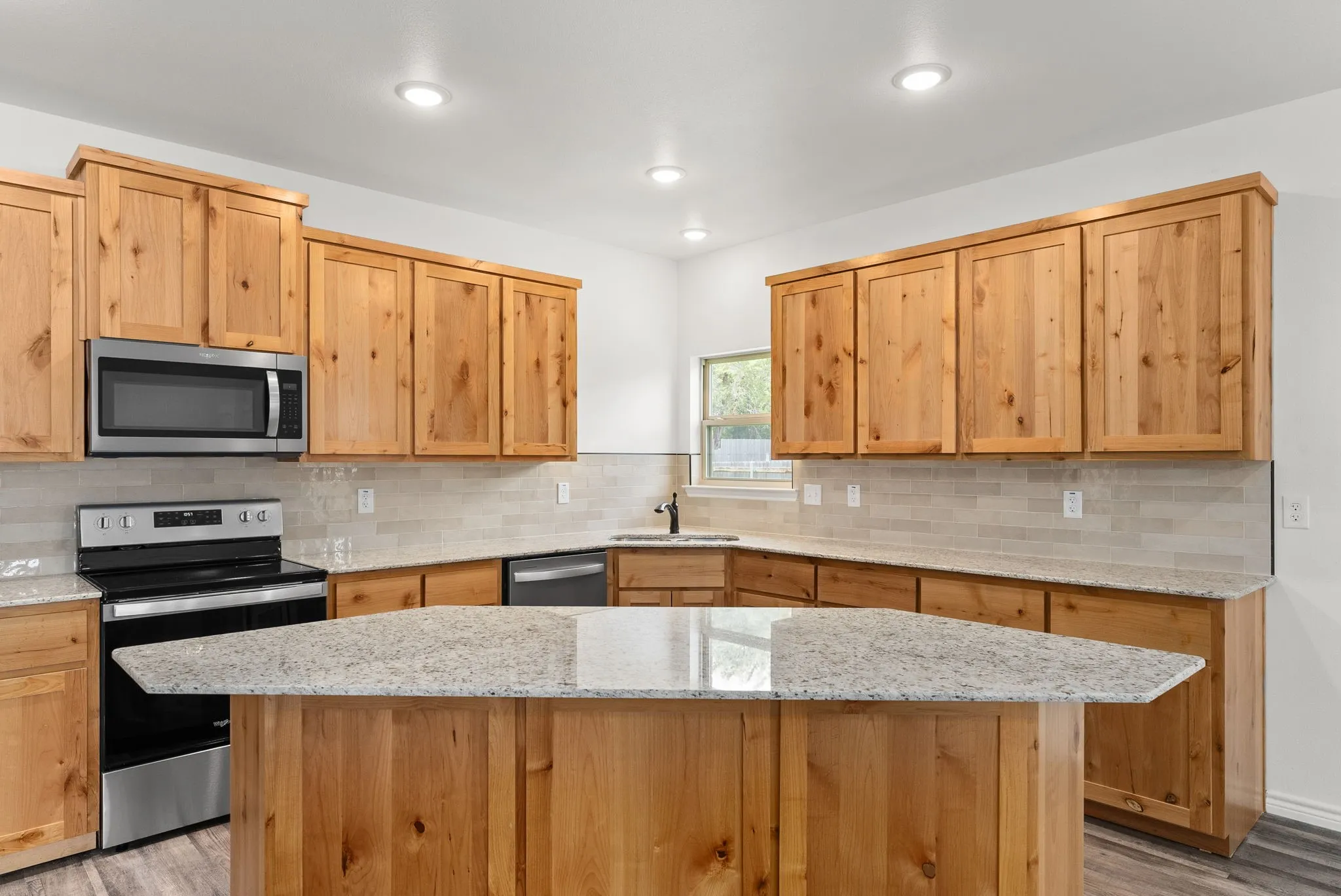 Kitchen featuring light wood cabinetry, recessed lighting, stainless steel appliances, a tile backsplash, and light-toned countertops