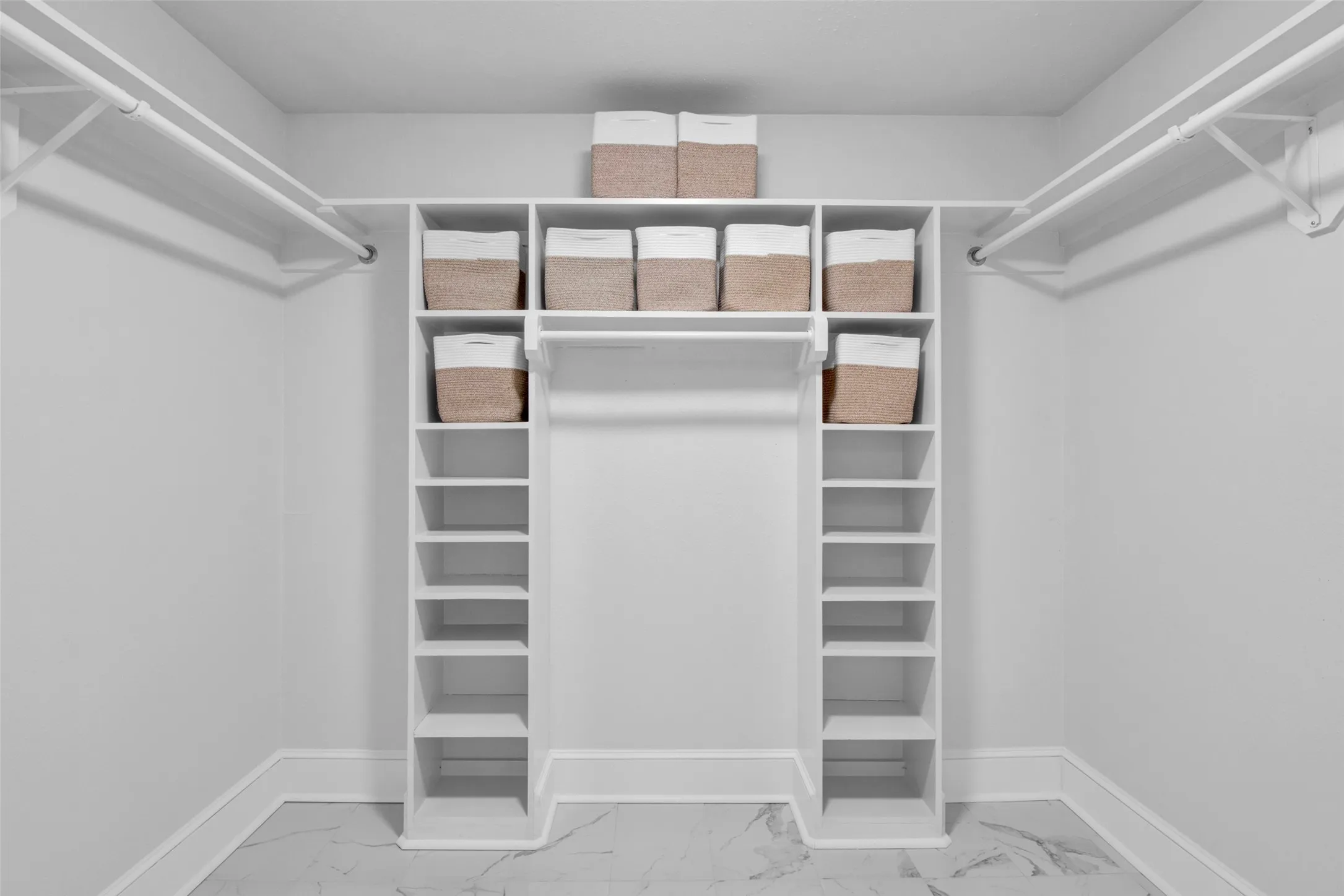 Built-in white shelving system featuring multiple storage compartments and hanging rods