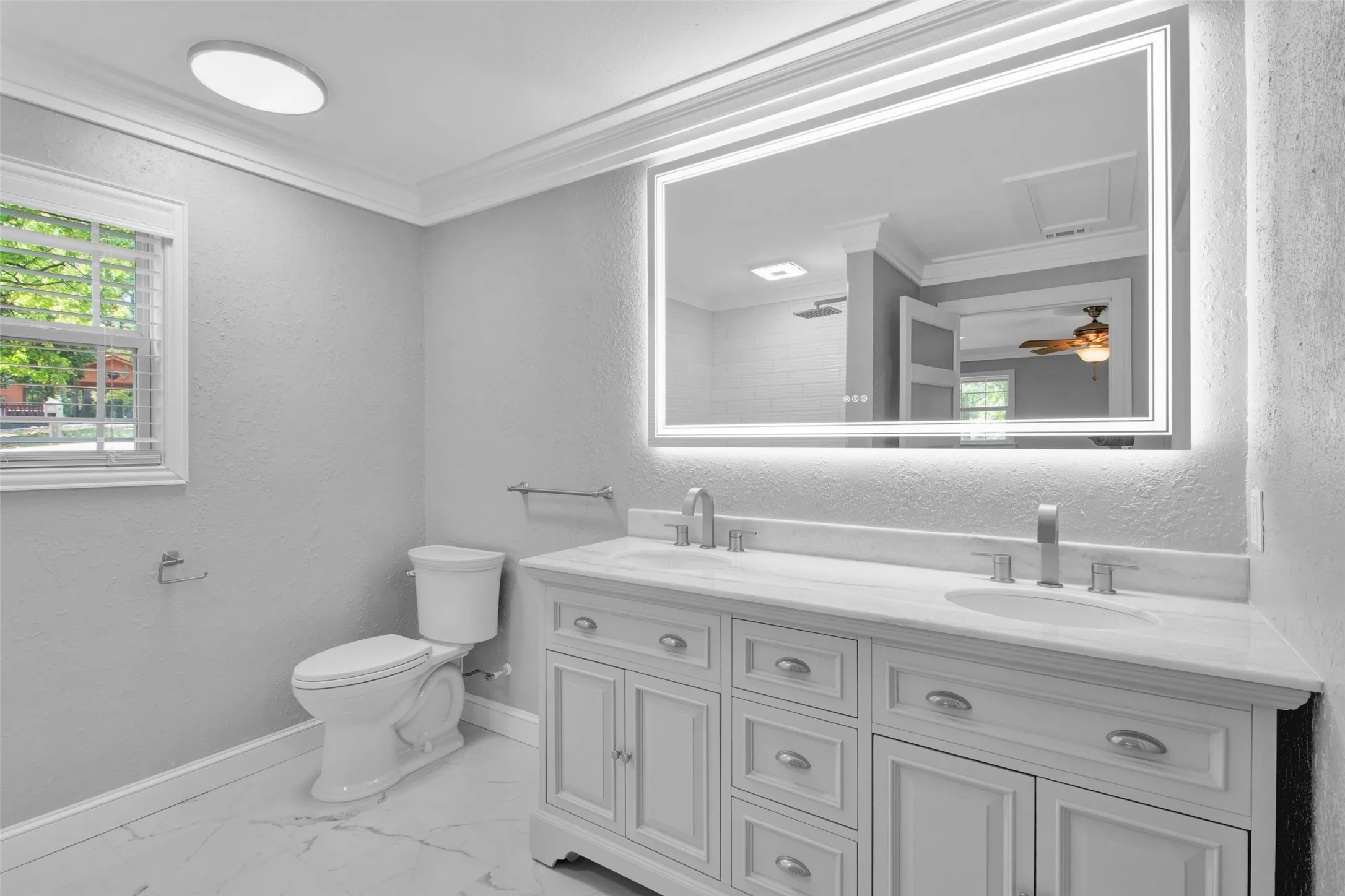 Double vanity with white cabinetry, dual undermount sinks, and a light-colored countertop