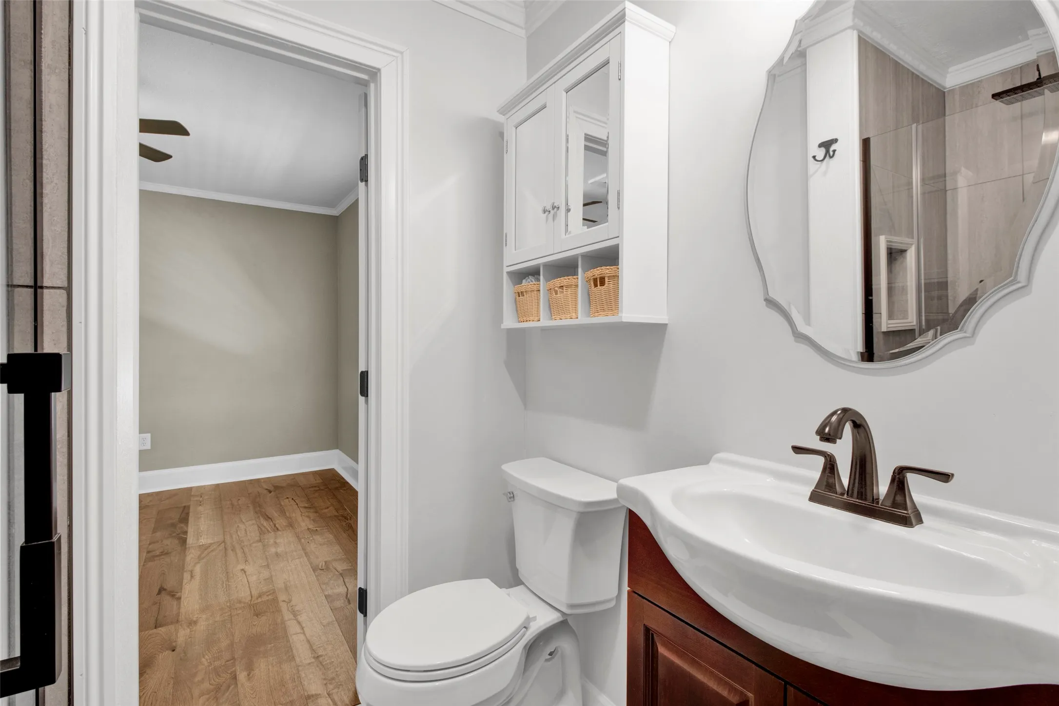 Bathroom featuring a single vanity, white porcelain sink, and wall-mounted storage cabinet