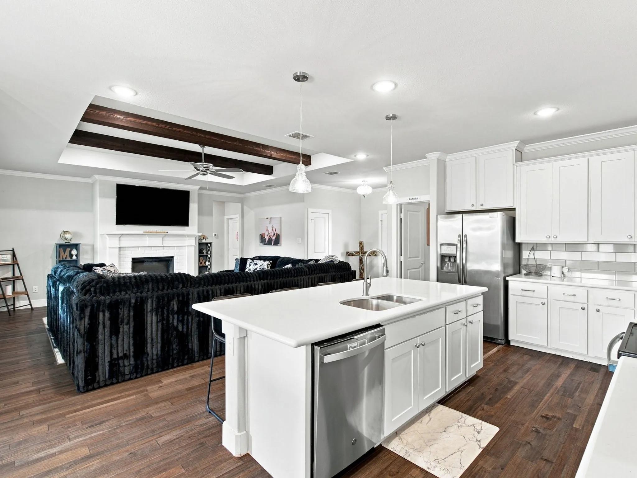 Kitchen with white cabinetry, stainless steel appliances, and a center island with sink