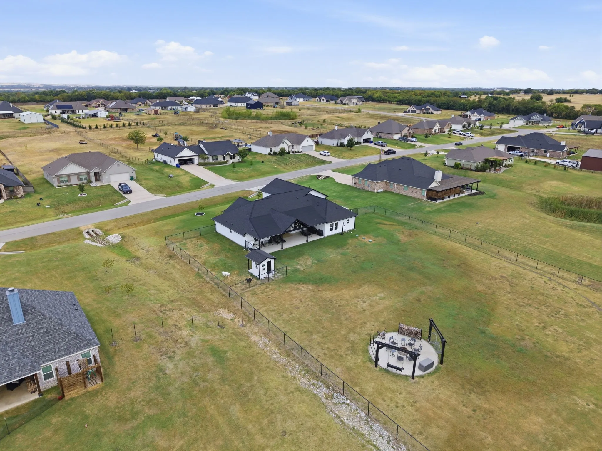 Expansive yard with chain link fencing and an outdoor patio