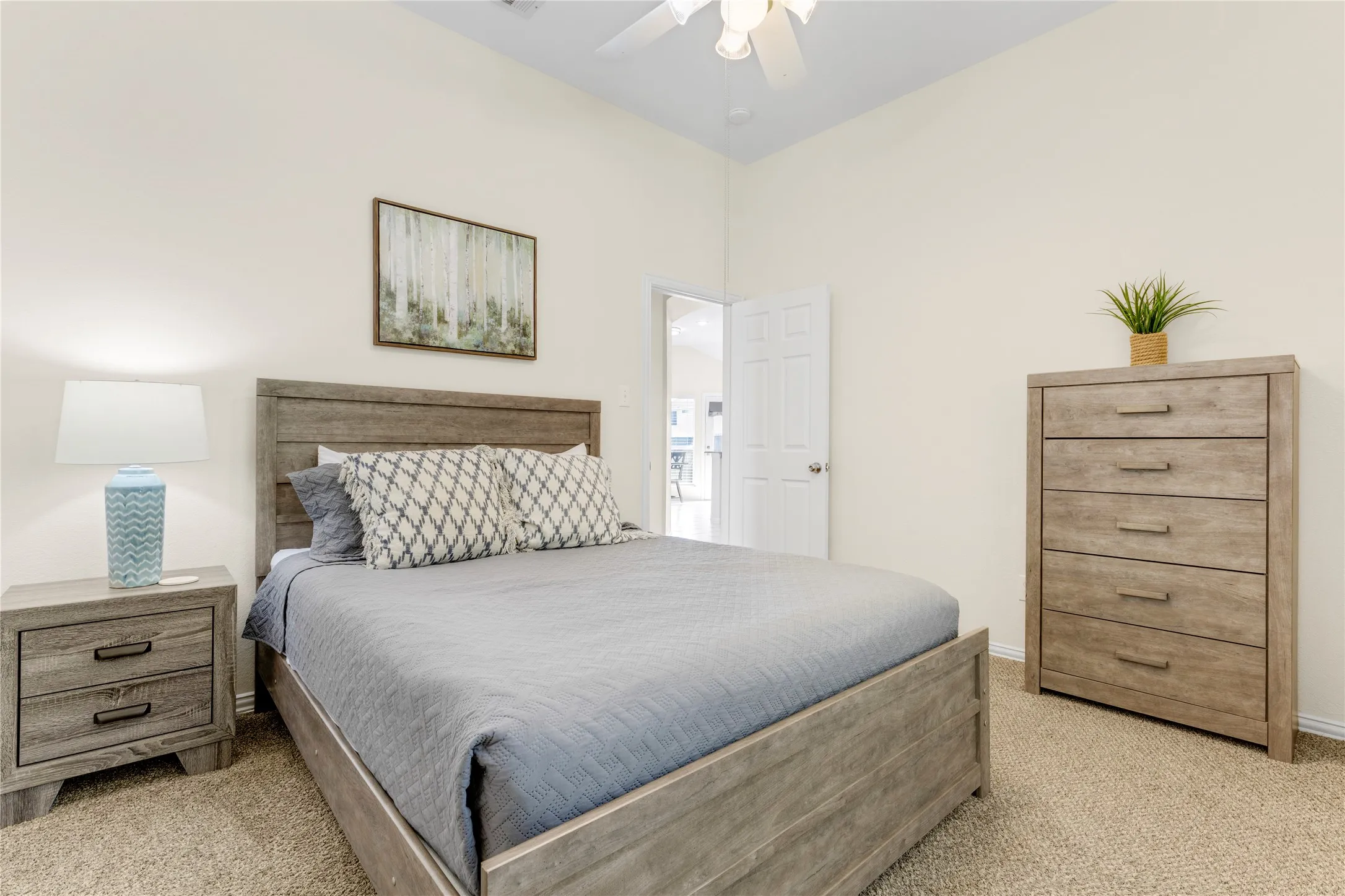 Vaulted ceiling with a ceiling fan, neutral wall tones, and carpeted flooring