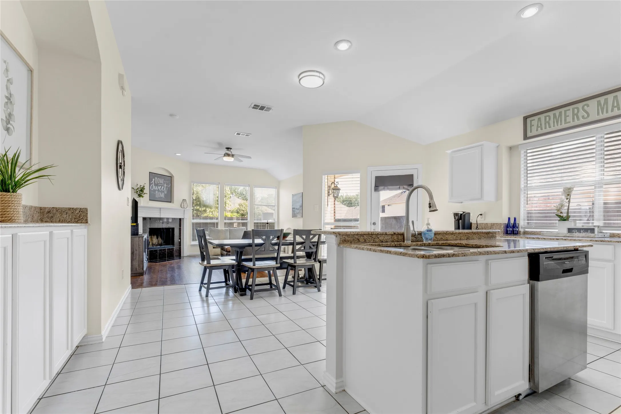 Kitchen with white cabinetry, granite countertops, and a stainless steel dishwasher