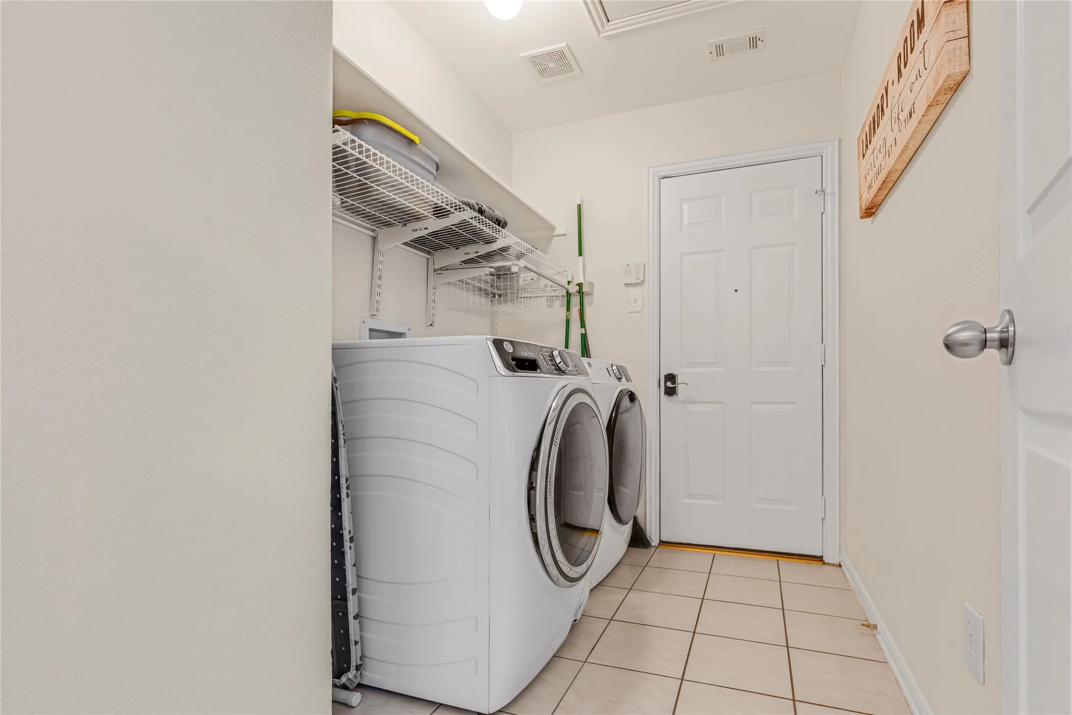Tile flooring, white paneled doors, and wall-mounted shelving