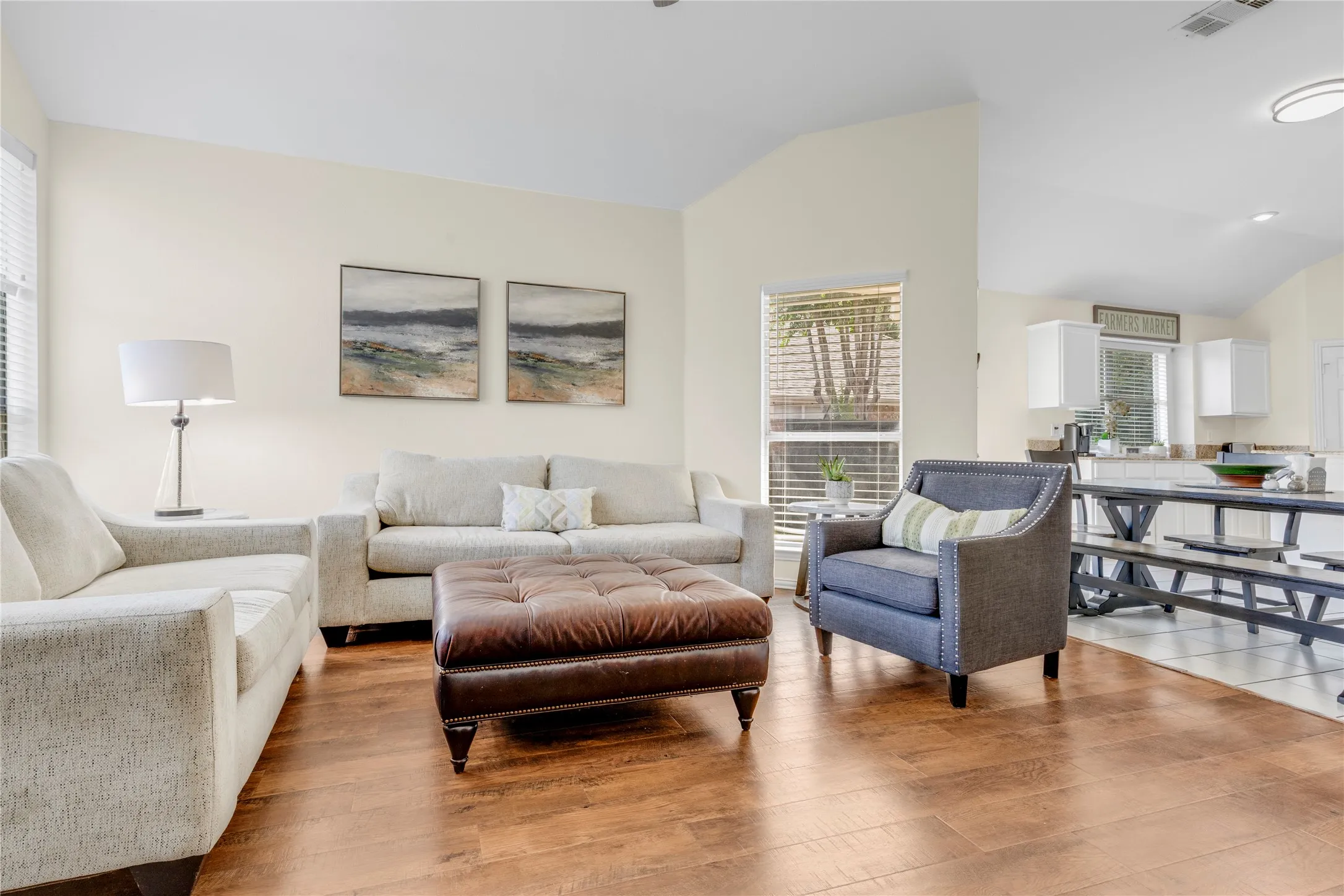 Vaulted ceilings, wood-finish flooring, and natural light from multiple windows