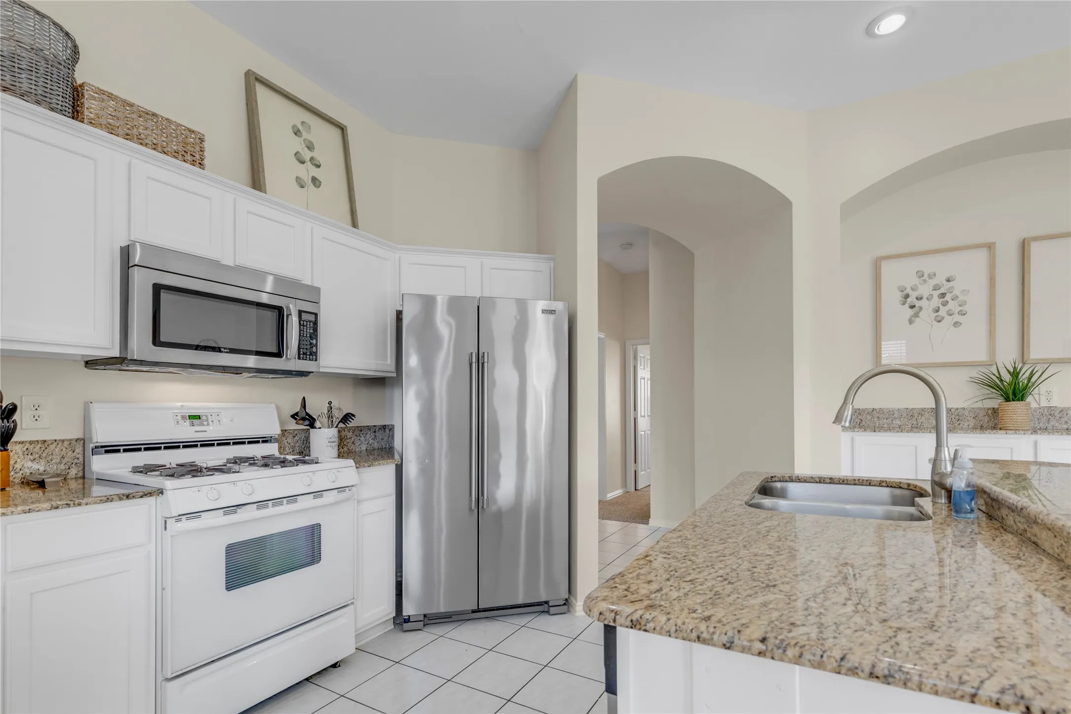 Kitchen featuring granite countertops, white cabinetry, stainless steel appliances, a gas range, and recessed lighting