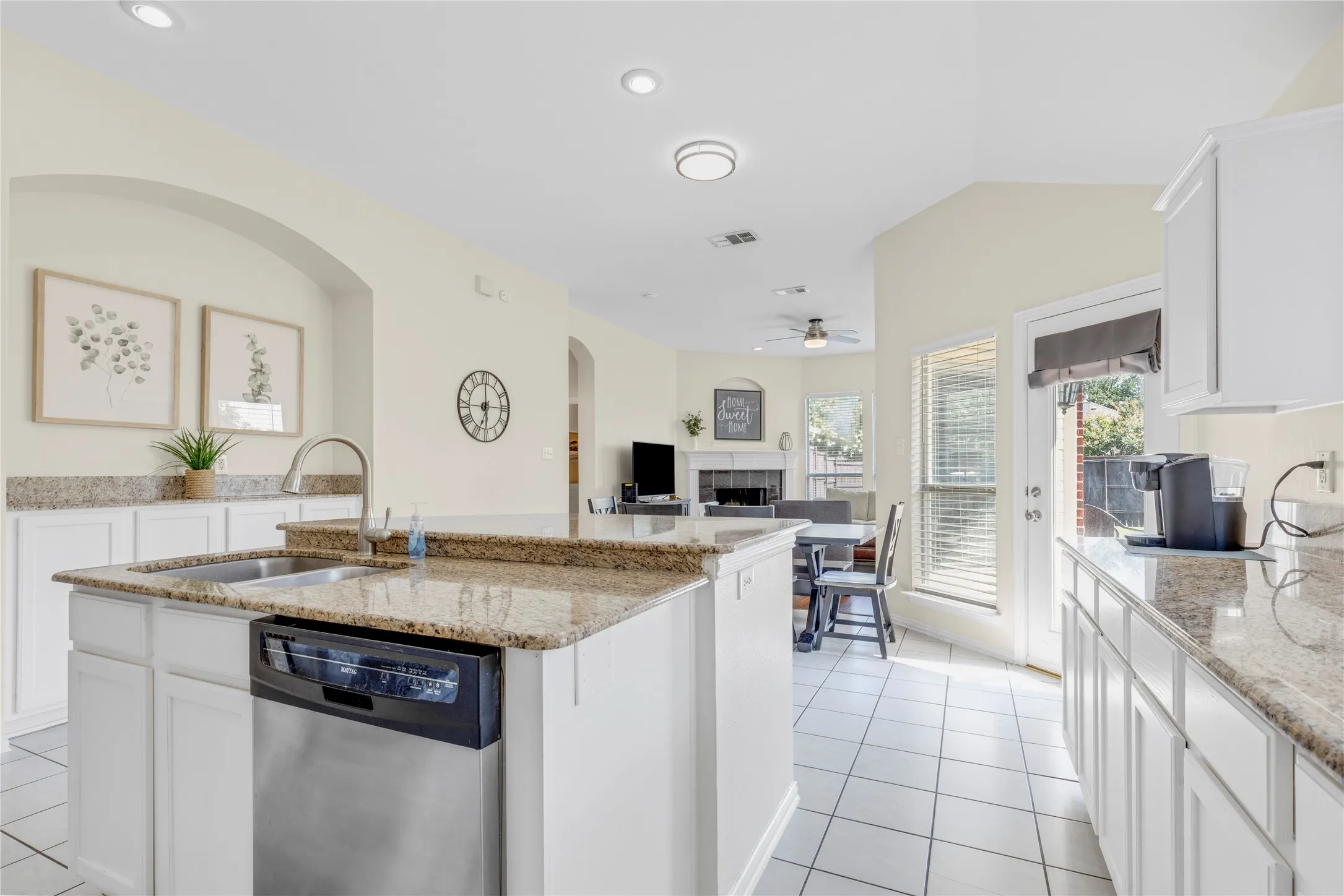 Kitchen featuring a stainless steel dishwasher, an undermount sink, granite countertops, white cabinetry, and recessed lighting