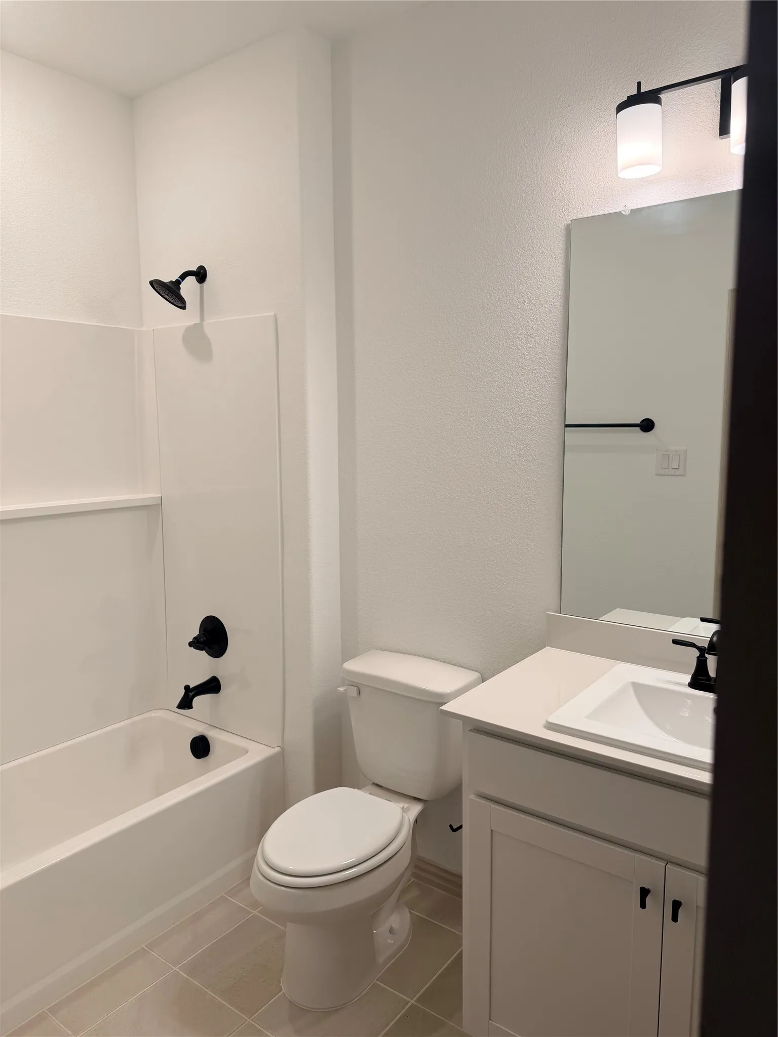 Guest Bathroom featuring a white vanity with a rectangular sink, a wall-mounted mirror, and a tub with a shower