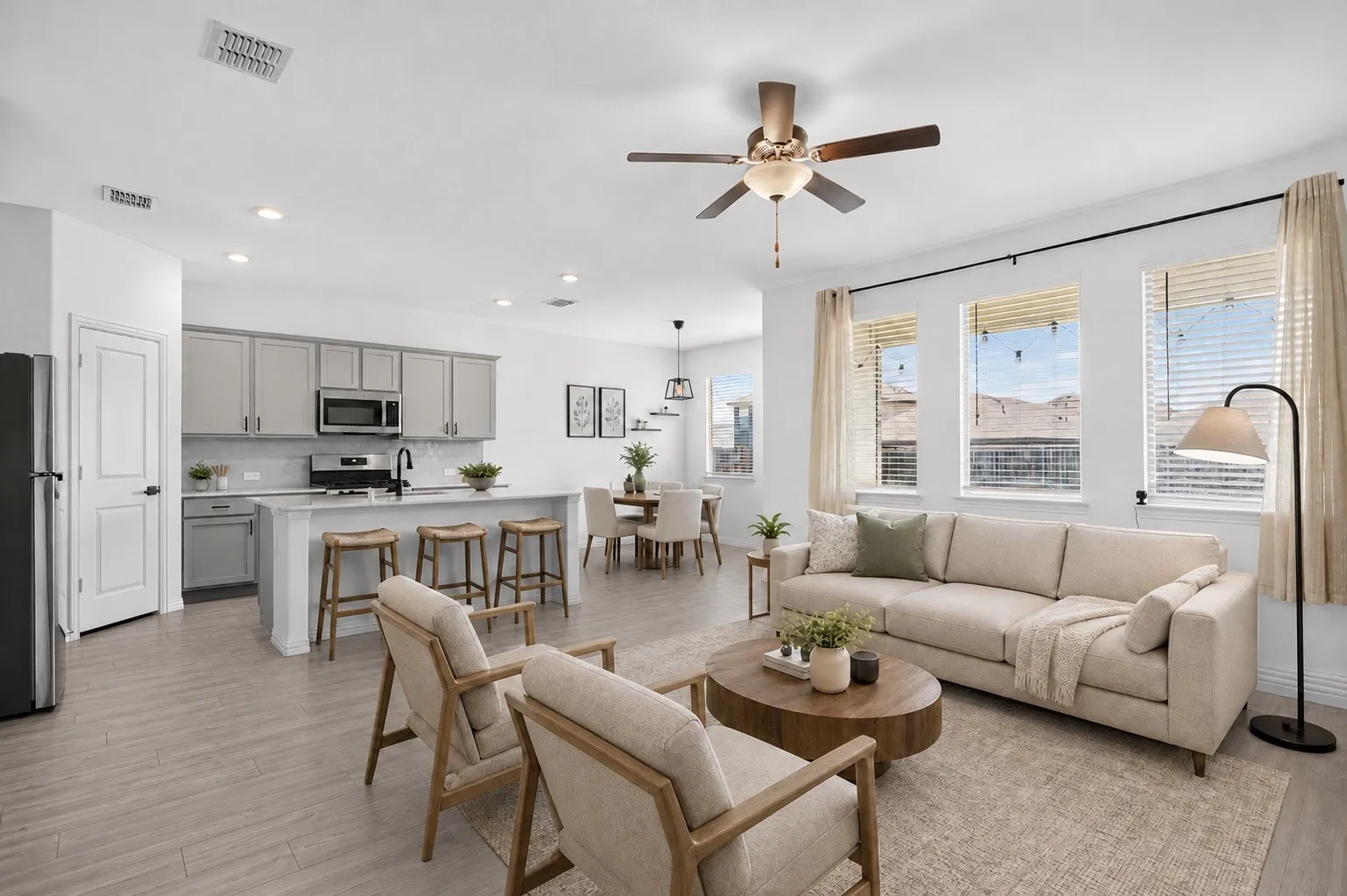 Open-concept living area featuring wood-finish flooring, recessed lighting, and a ceiling fan